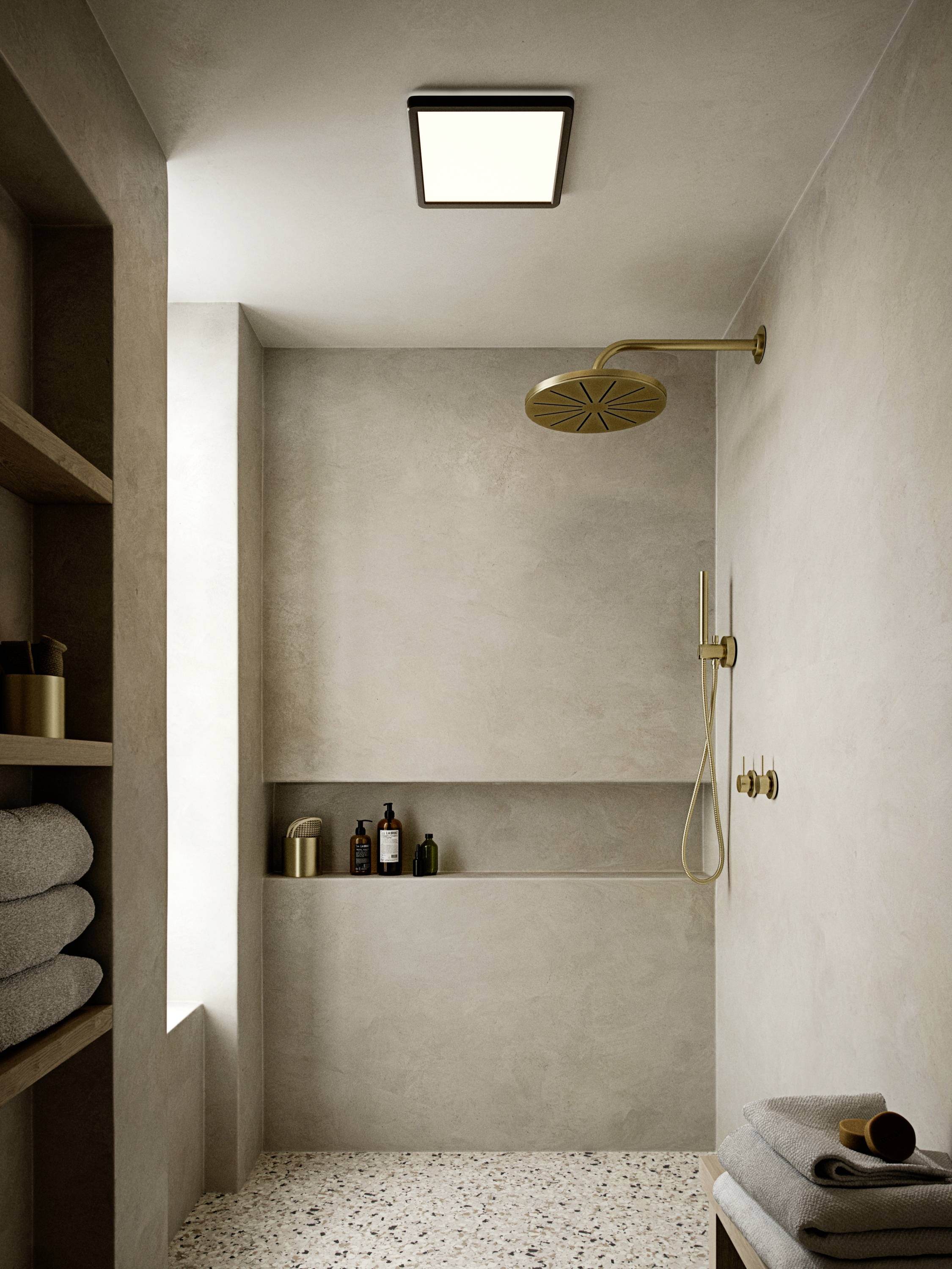 Salle de bain élégante au design minimaliste : douche de type pluie, palette de couleurs beige, niches pour produits de soin et serviettes.