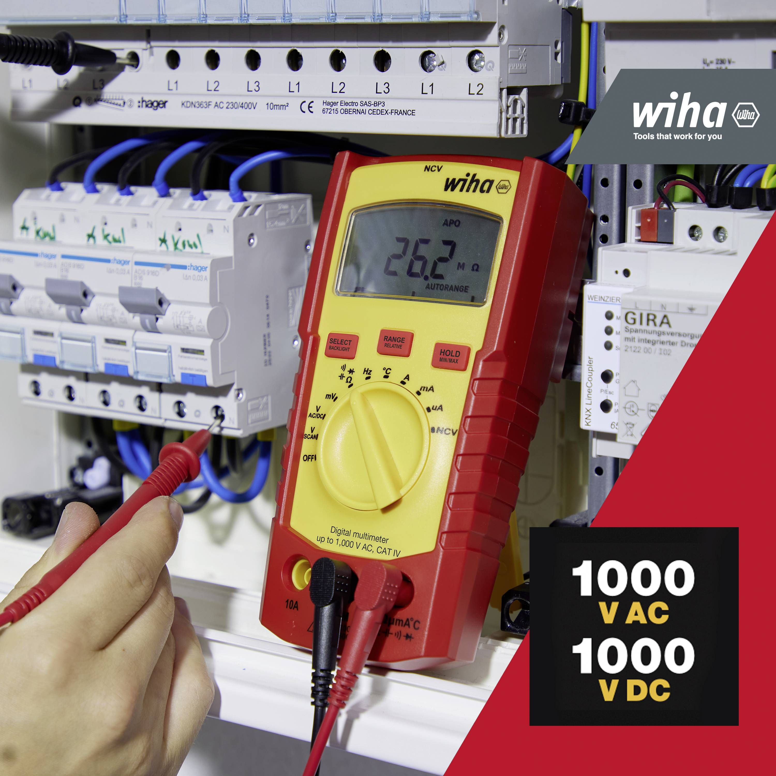 Une personne mesure avec un multimètre sur un boîtier électrique. Affichage : 260 V. Graphiques : '1000 V AC, 1000 V DC'. Marque Wiha visible.