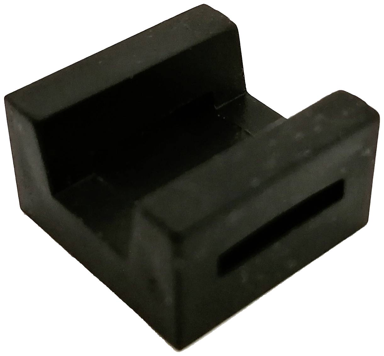 Un support en plastique noir, rectangulaire, avec un dessus ouvert et un creux au centre, probablement destiné à maintenir quelque chose en place.