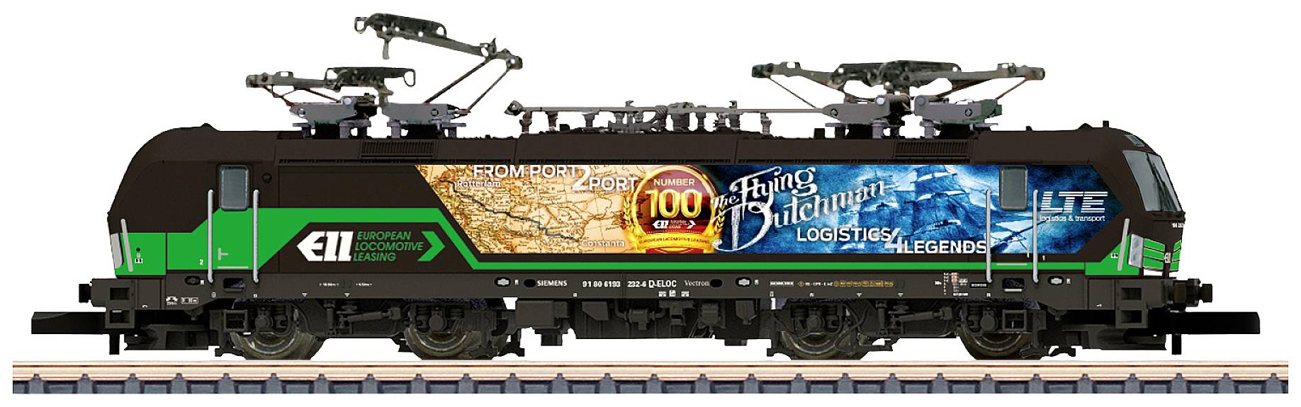 Une locomotive électrique moderne à peinture verte et noire. La bannière publicitaire à droite montre la ligne de parcours et l'anniversaire de sa construction.