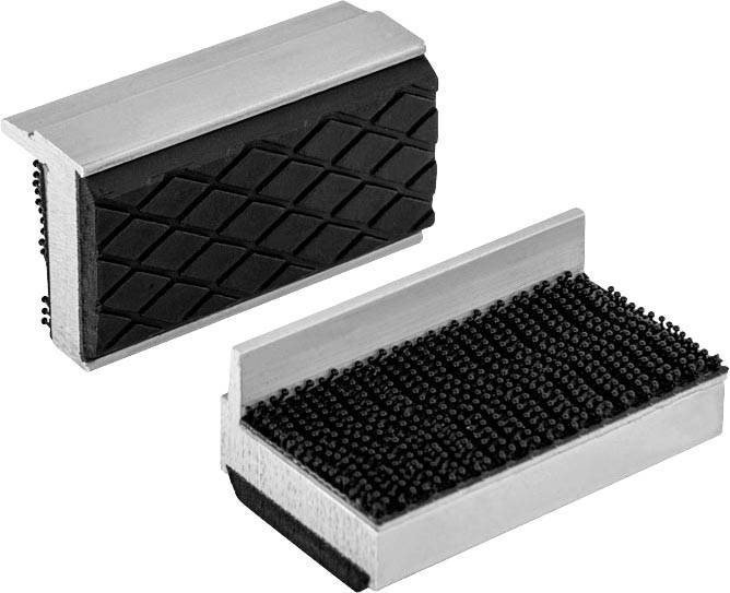Deux mâchoires d'étau en argent et en noir avec des structures de surface différentes, l'une avec un motif en losange, l'autre grossièrement texturée.