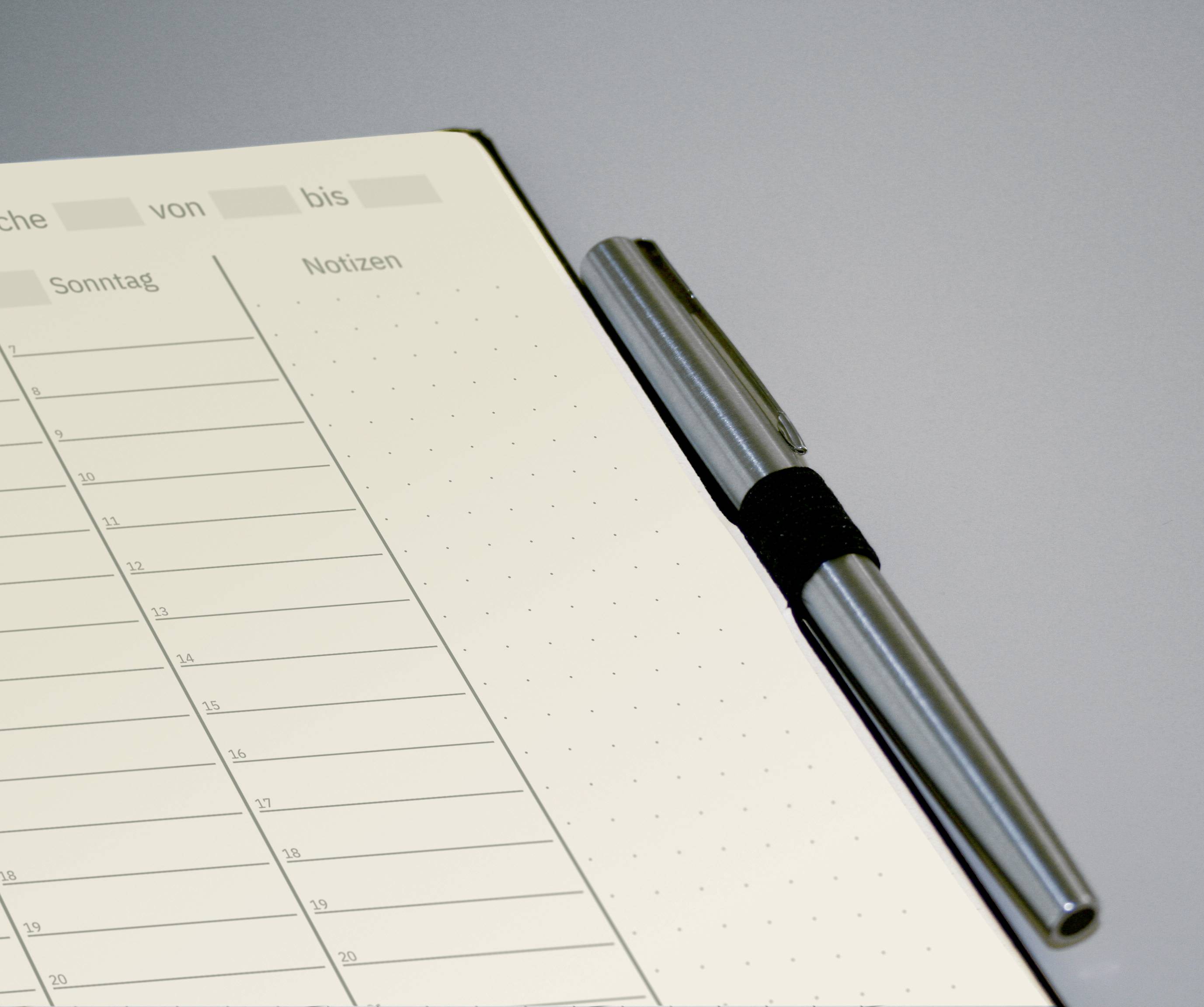 Un carnet ouvert est posé sur une table. À gauche, des jours et des heures sont inscrits de manière tabulaire, à droite, il y a de l'espace pour des notes. Un stylo est posé à côté.