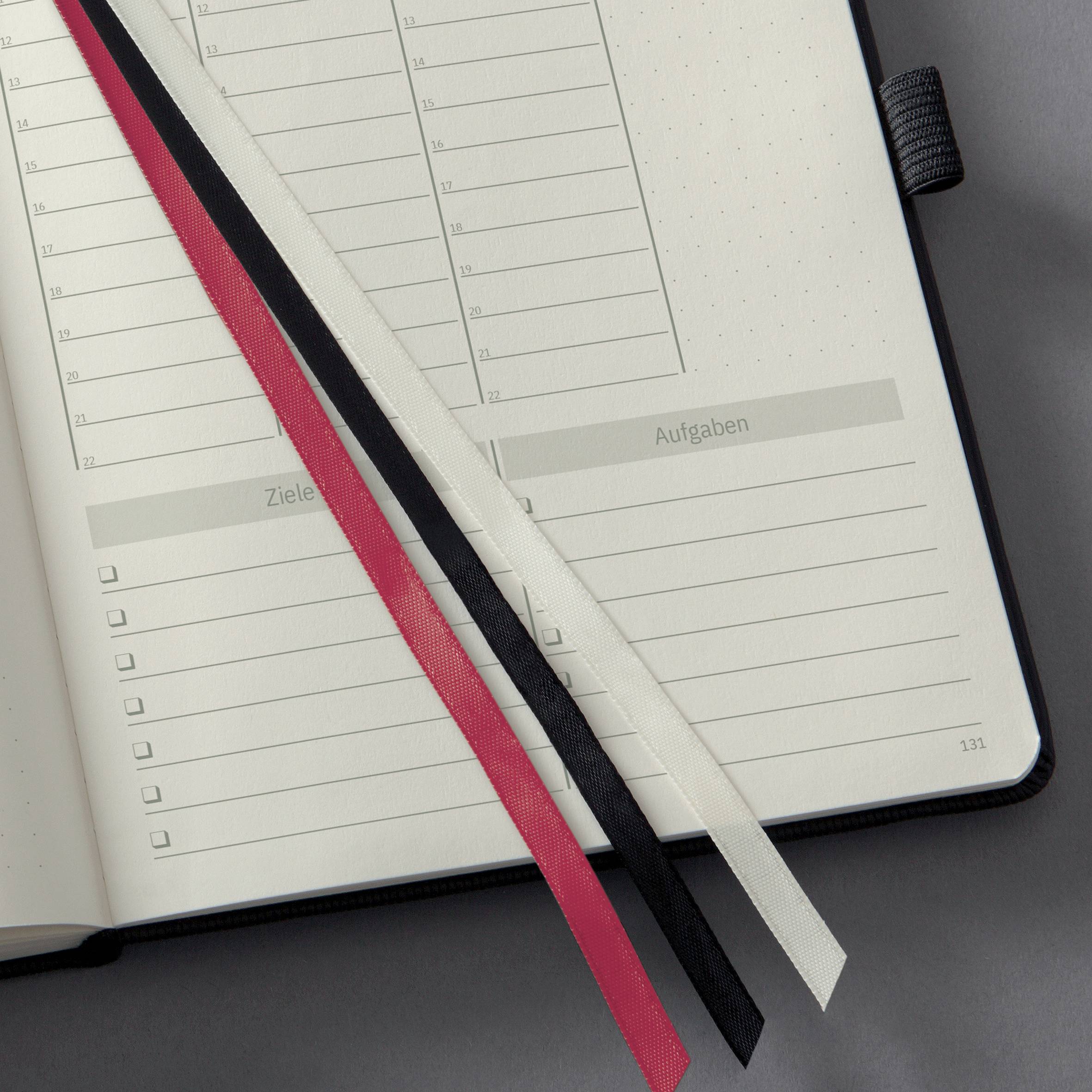 Un agenda ouvert avec trois signets en rouge, noir et blanc. À gauche des dates, à droite 'Objectifs' et 'Tâches'.
