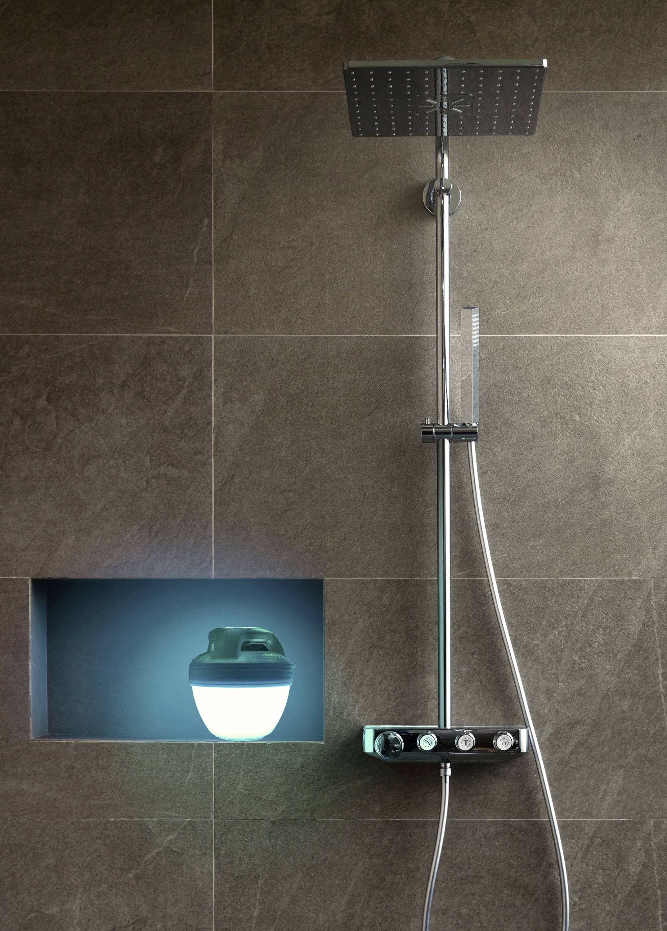 Une douche moderne avec un pommeau de douche rectangulaire en acier inoxydable et un compartiment de niche éclairé contenant du gel douche.