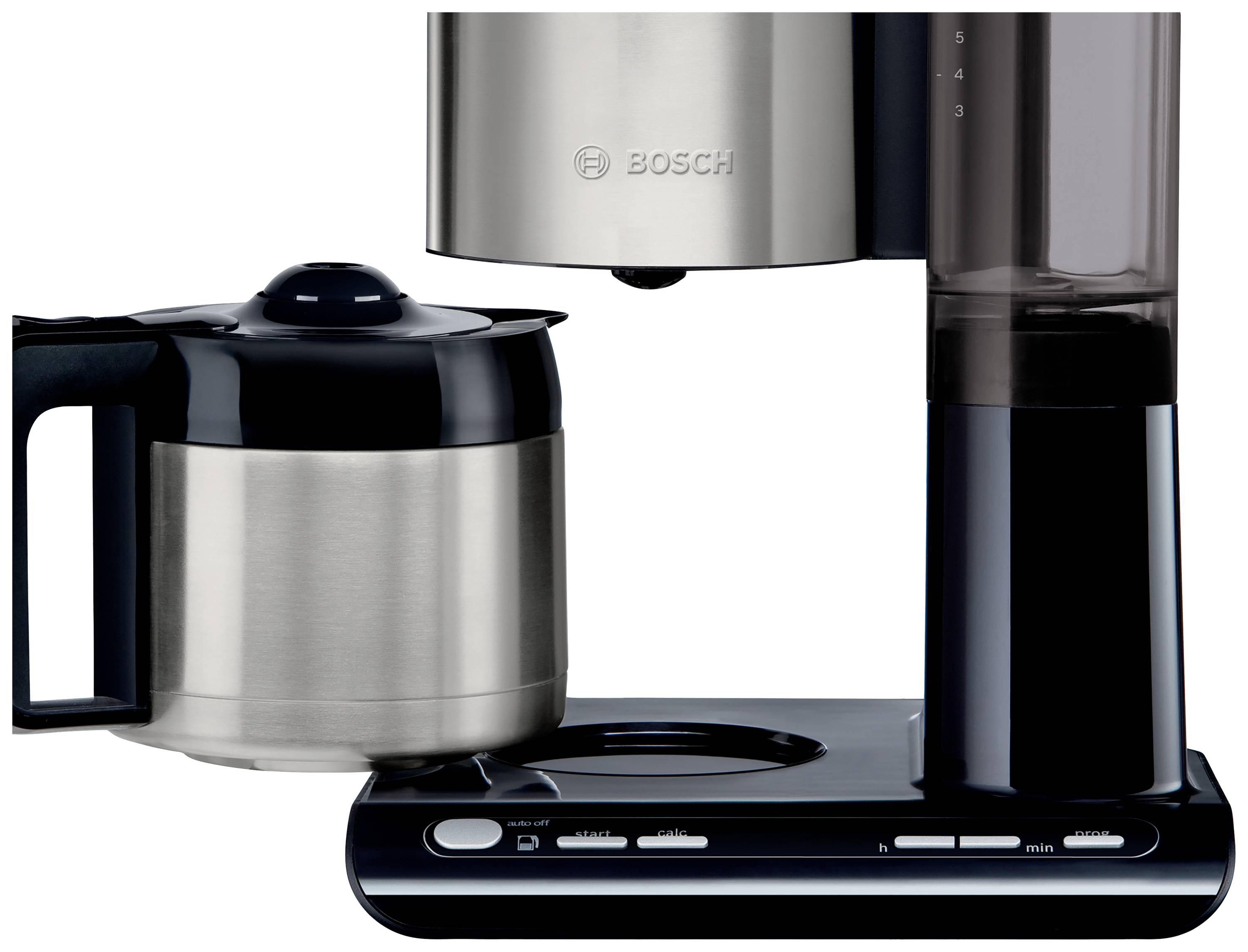 Un cafetier automatique en argent et noir avec une carafe en acier inoxydable et des commandes à la base.