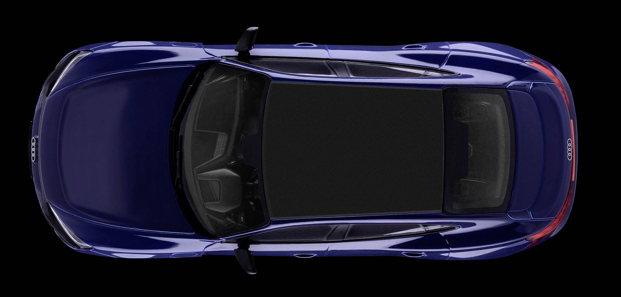 Voiture bleue vue de dessus contre un fond noir, montrant le toit et les deux rétroviseurs latéraux.