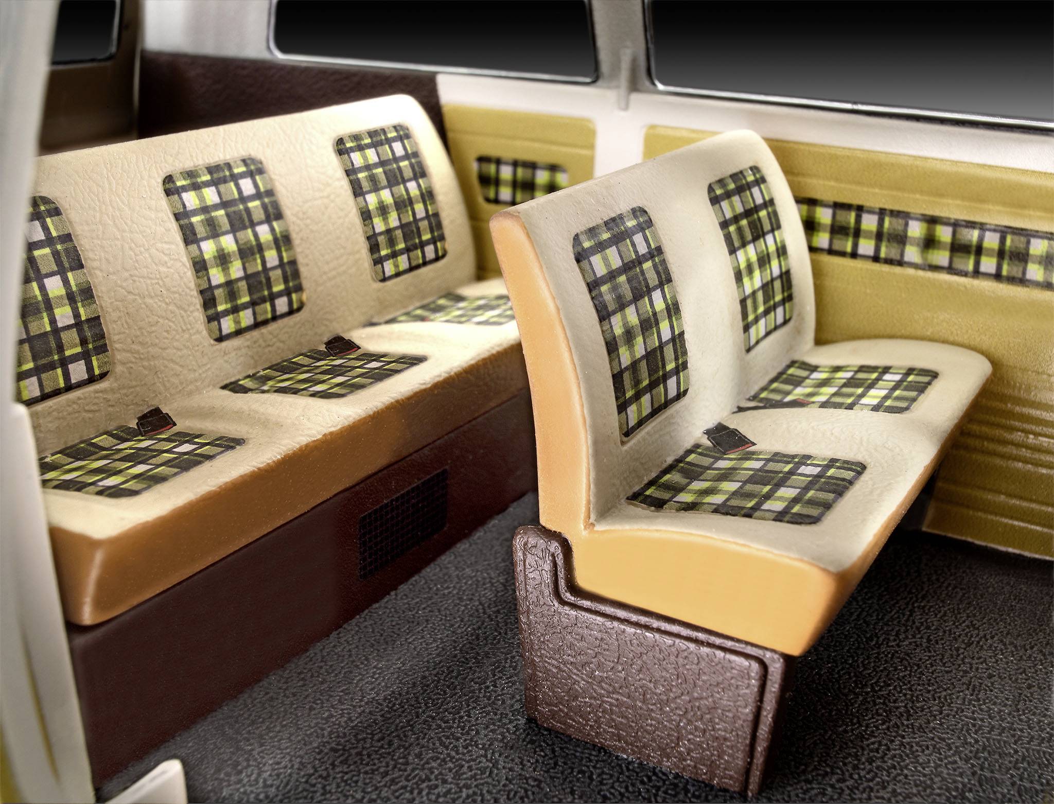 Intérieur d'un véhicule avec des sièges à carreaux dans des tons de marron et de beige. Banquette arrière et siège latéral visibles.