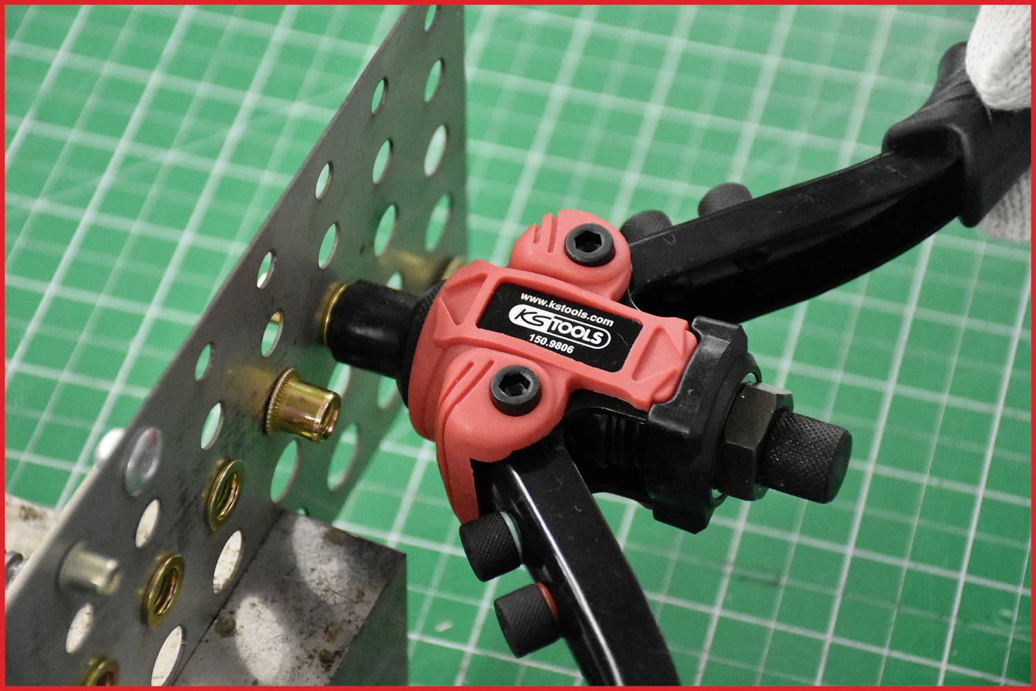 Une pince à riveter relie une plaque métallique à un rivet. L'action est démontrée sur un support vert.