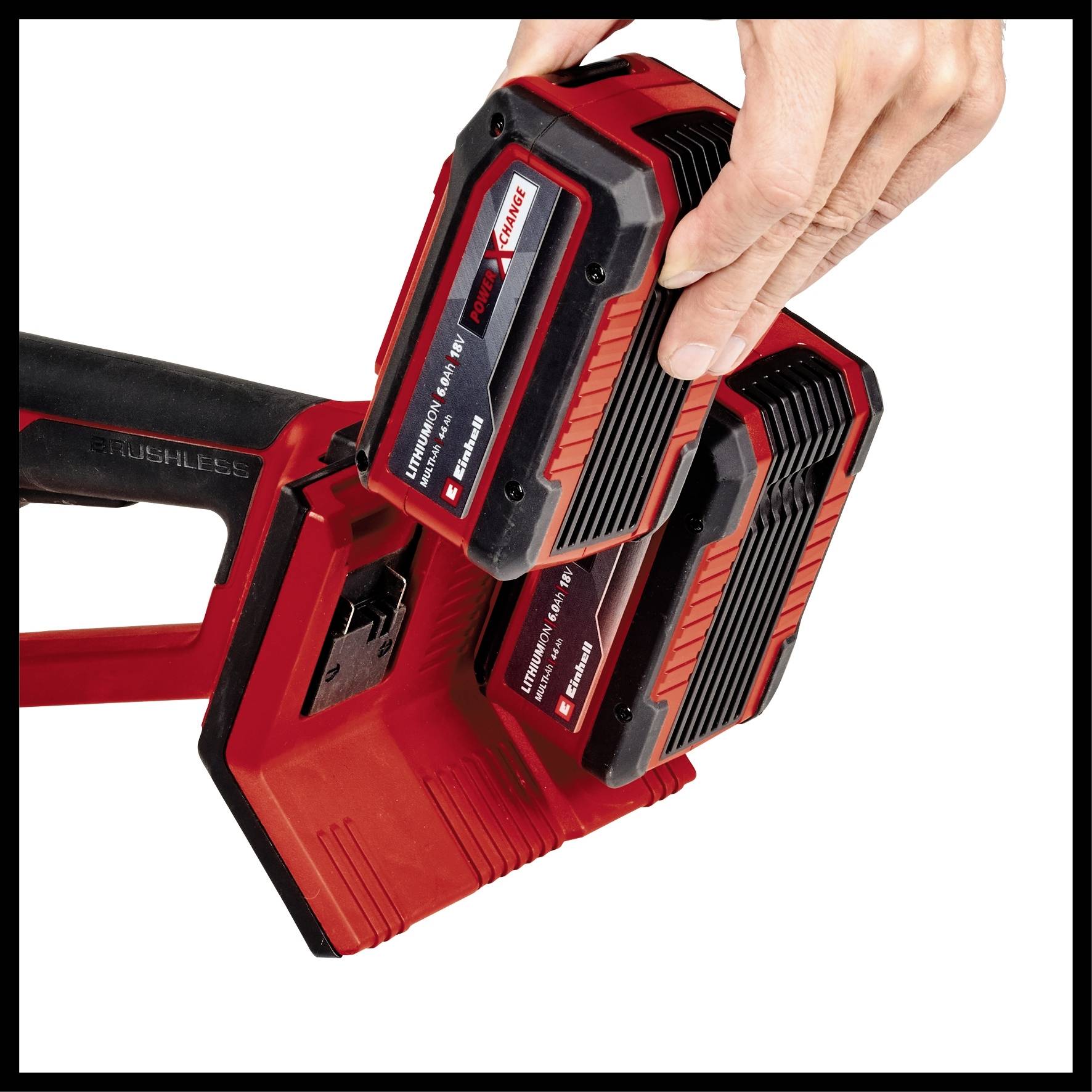 Une main insère une batterie d'outil électrique rouge dans un chargeur adapté. La batterie est noir et rouge avec des inscriptions.