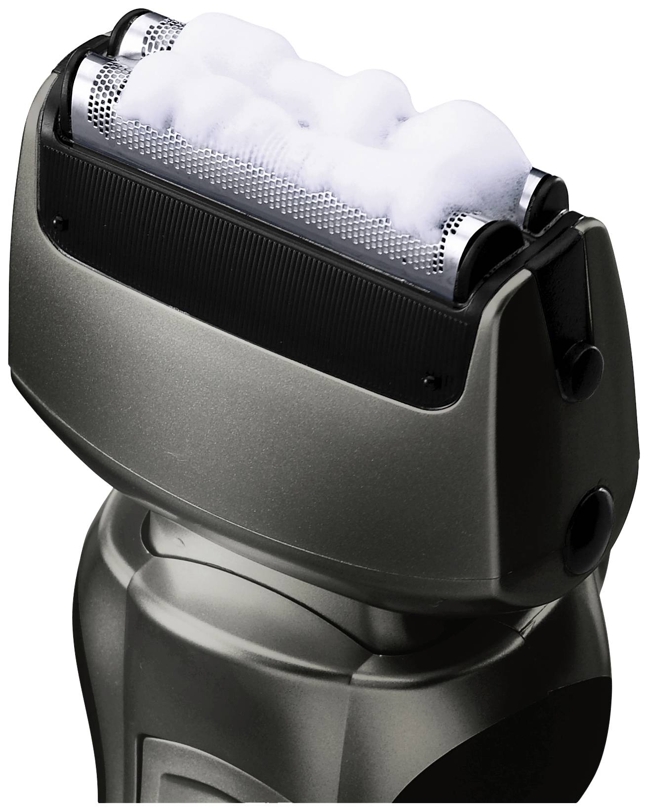 Rasoir électrique avec de la mousse appliquée sur les lames, gros plan sur les têtes de rasage au design en métal noir.