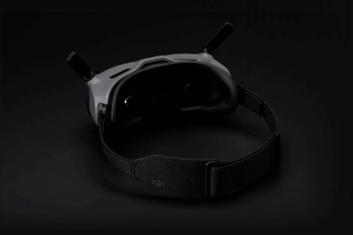 Lunettes de réalité virtuelle avec sangle noire sur fond sombre.