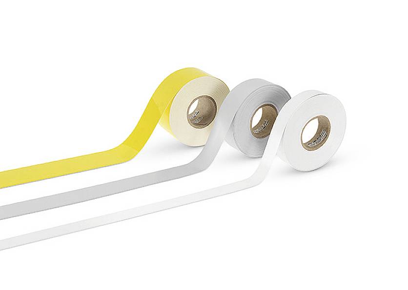 Trois rouleaux de ruban adhésif coloré : jaune, gris et blanc. Chaque rouleau est partiellement déroulé, montrant des bandes de la couleur respective.