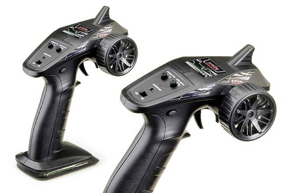 Deux télécommandes noires pour voiture télécommandée, équipées de volants et de commandes sur leur partie supérieure, adaptées aux modèles réduits automobiles.