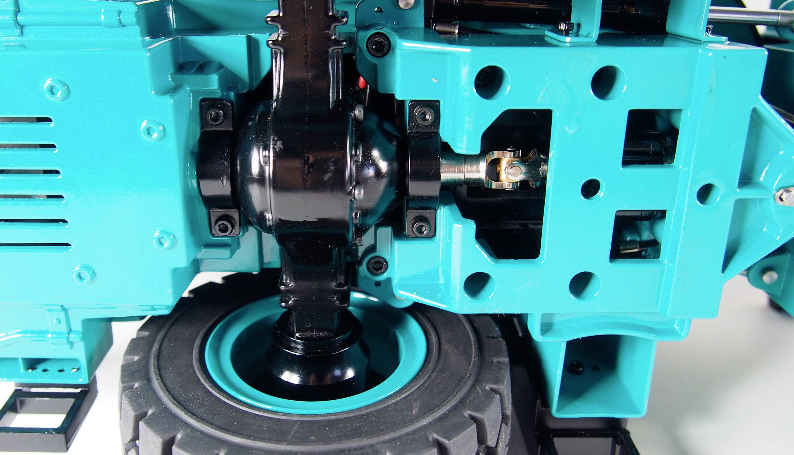 Un robot ou engin de construction de couleur turquoise avec un engrenage visible et une articulation noire. L'accent est mis sur la mécanique technique.