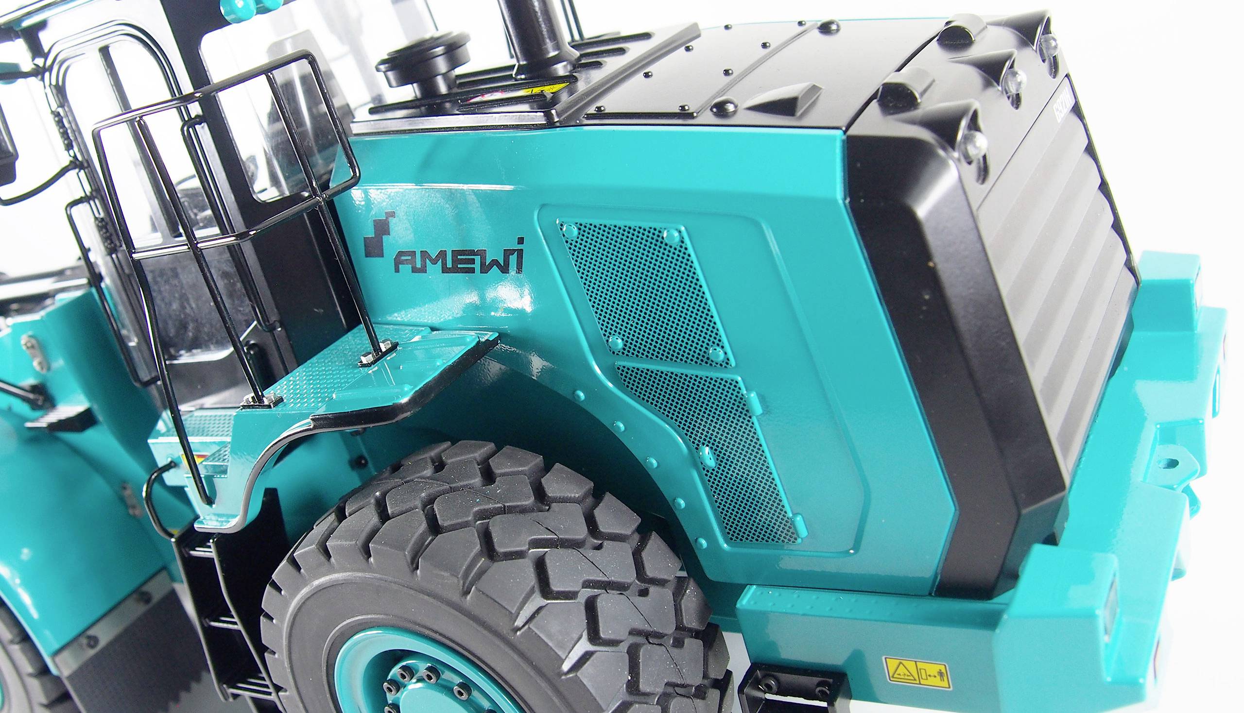 Un tracteur miniature turquoise aux détails soignés, avec des roues en plastique ; le nom de marque 'Amewi' est inscrit sur le côté.