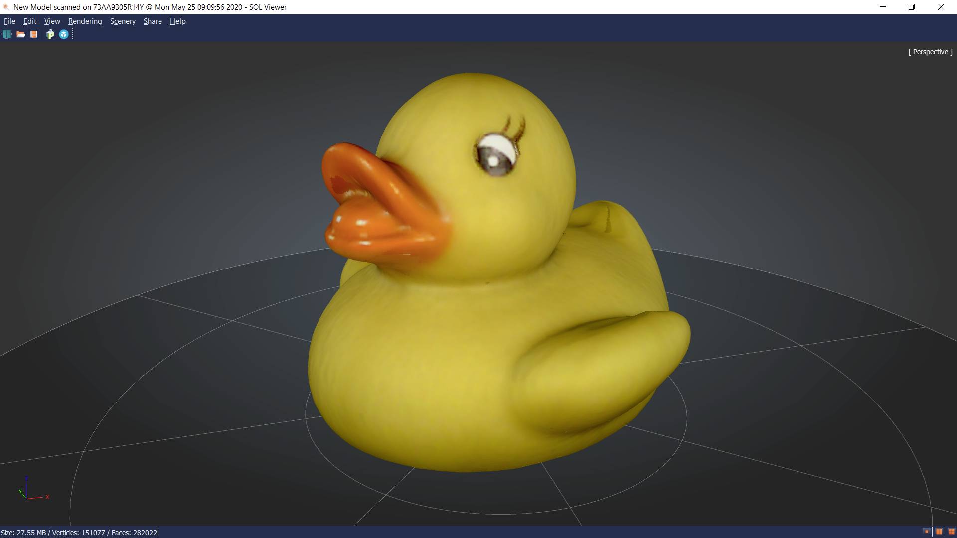 Un canard en caoutchouc jaune avec un bec orange sur une surface neutre grise. Le canard regarde légèrement vers la gauche.
