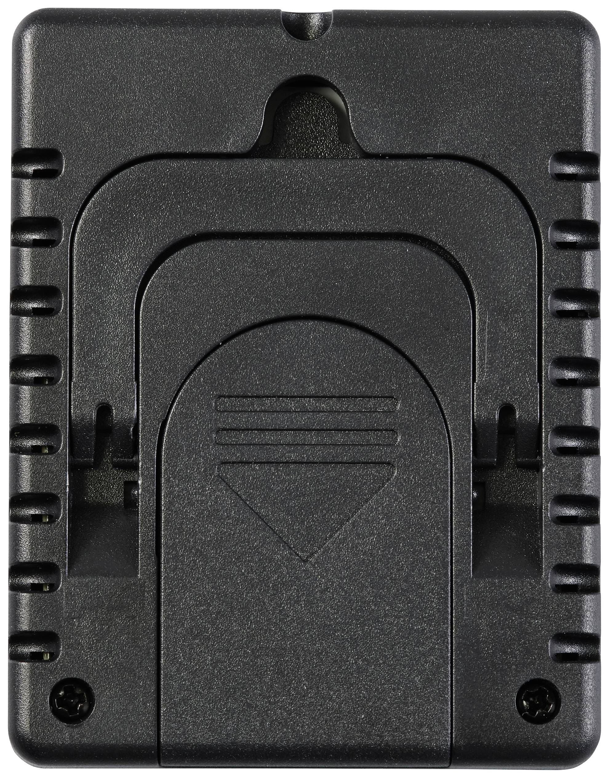 Un appareil électronique noir à surface structurée et présentant plusieurs rainures. Il semble s'agir d'un adaptateur de batterie ou d'un chargeur.