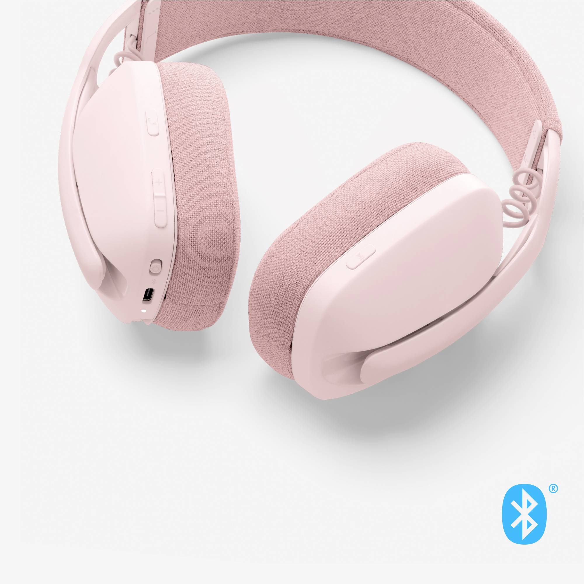 Écouteurs Bluetooth sans fil roses avec coussinets doux et boutons de contrôle sur le côté.