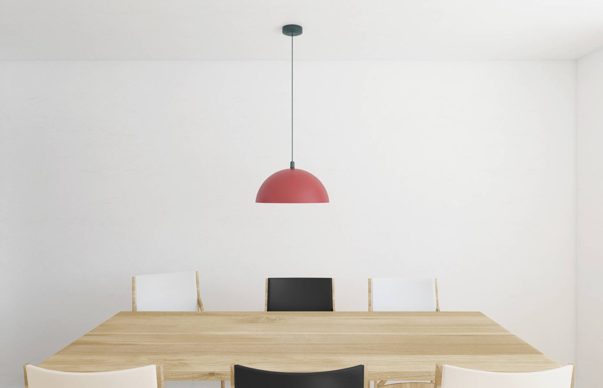 Un espace minimaliste avec une table à manger en bois, entourée de deux chaises blanches et deux chaises noires. Un luminaire suspendu rouge est accroché au centre au-dessus de la table.