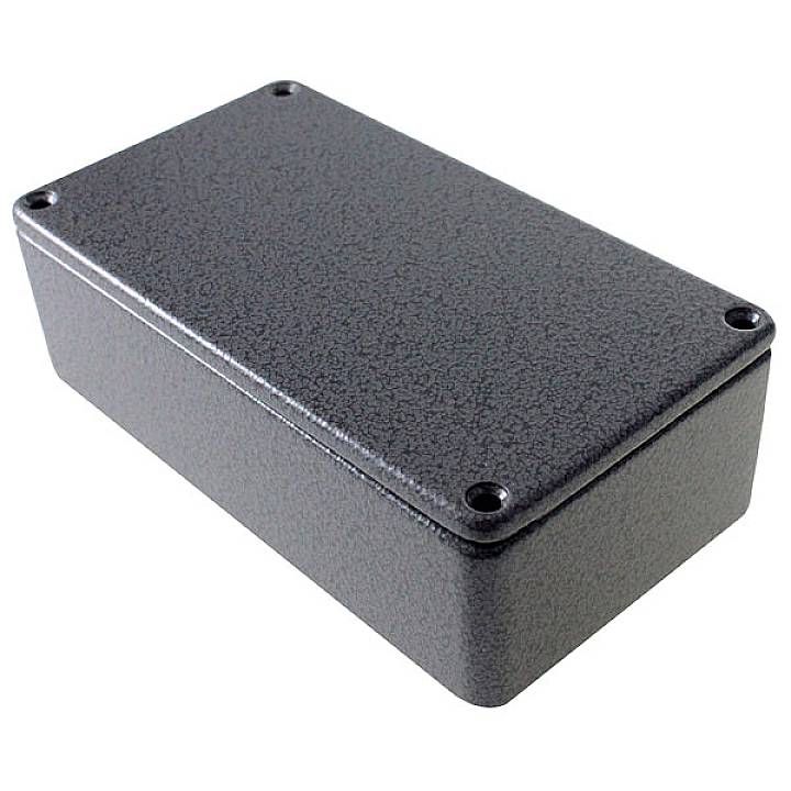Boîtier noir rectangulaire aux angles arrondis, muni de quatre vis aux coins de sa surface.