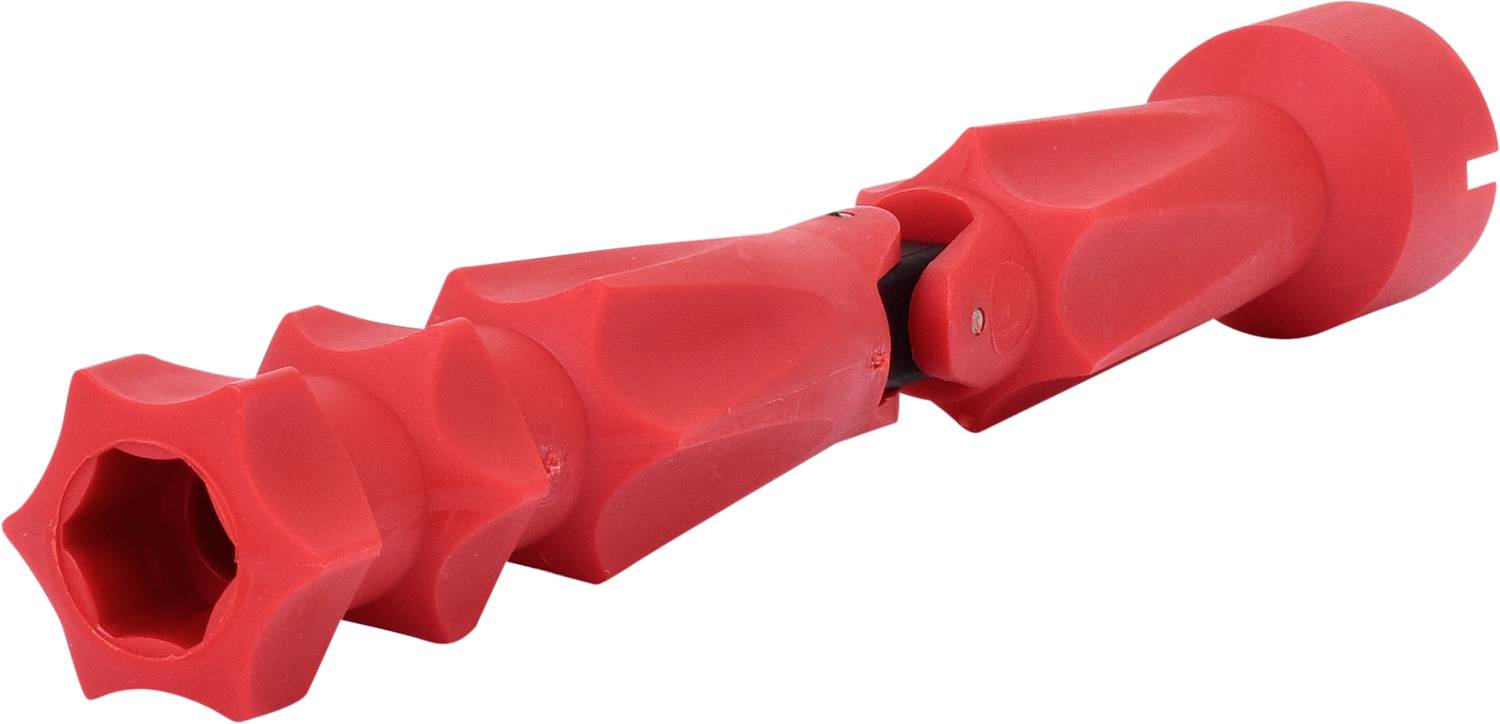 Un objet rouge en plastique à la structure facettée et ondulante, ressemblant à un composant mécanique ou un outil.