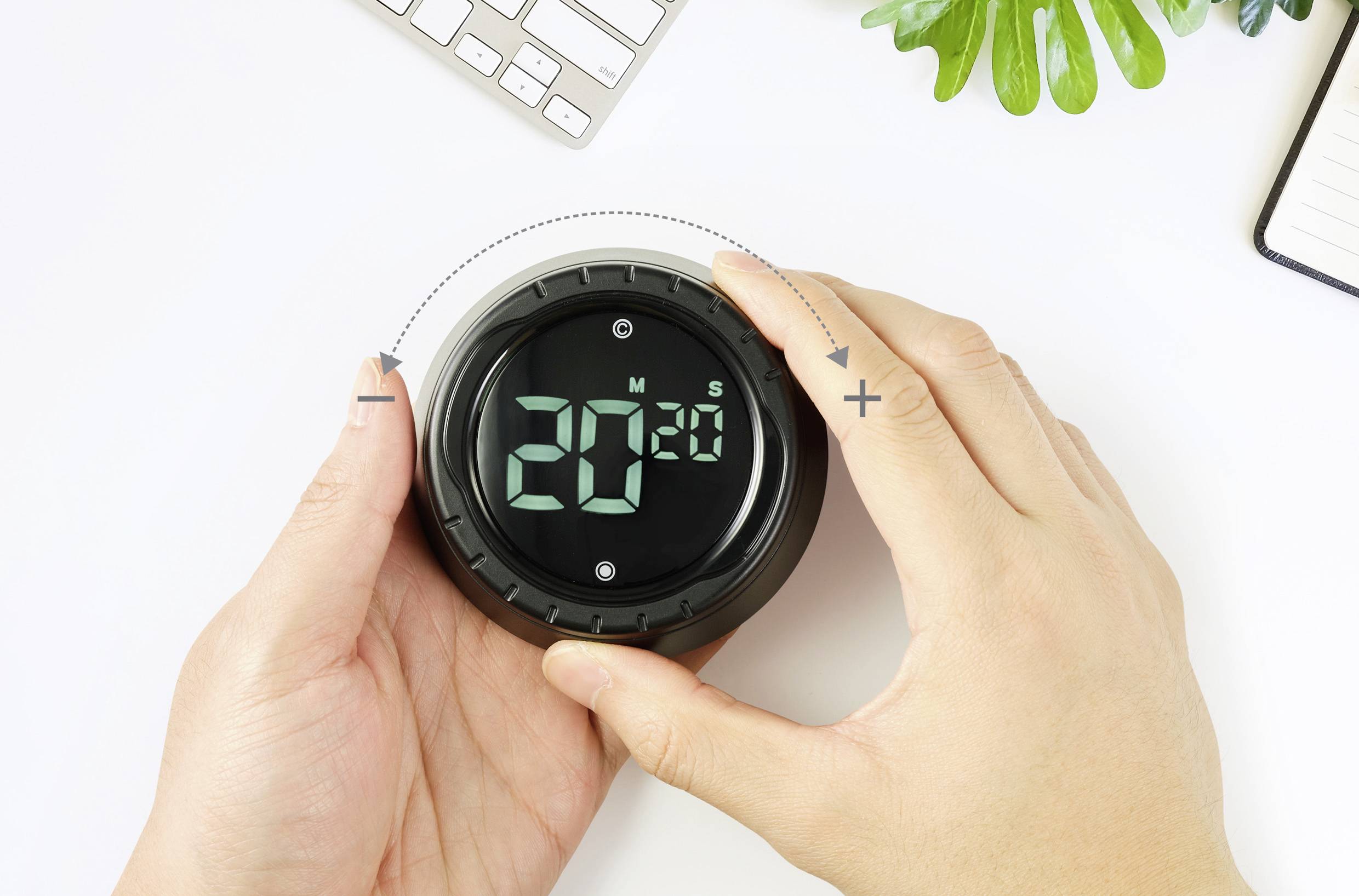 Une personne règle un minuteur numérique sur 20 minutes. Le minuteur possède une touche Plus et une touche Moins pour modifier le temps.