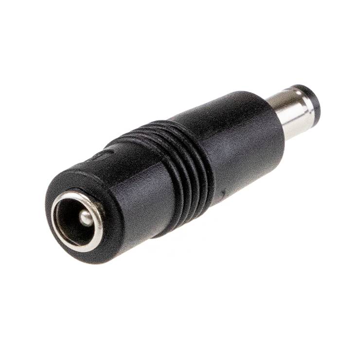 Un adaptateur DC noir avec une prise mâle ronde sur une surface blanche.
