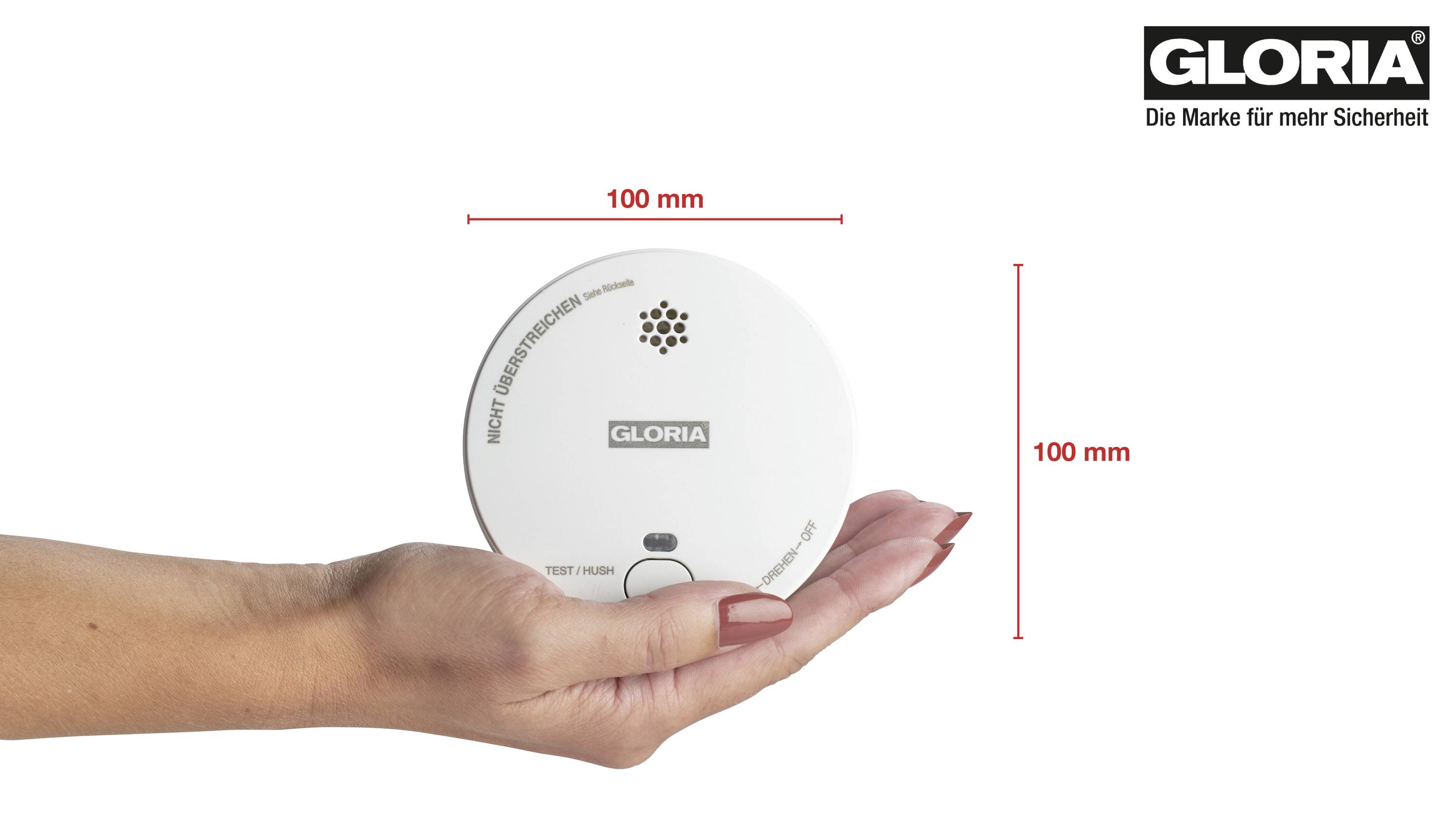 Une main tient un détecteur de fumée rond. À côté se trouvent des flèches indiquant une taille de 100 mm en hauteur et en largeur. En haut à droite est inscrit 'GLORIA'.