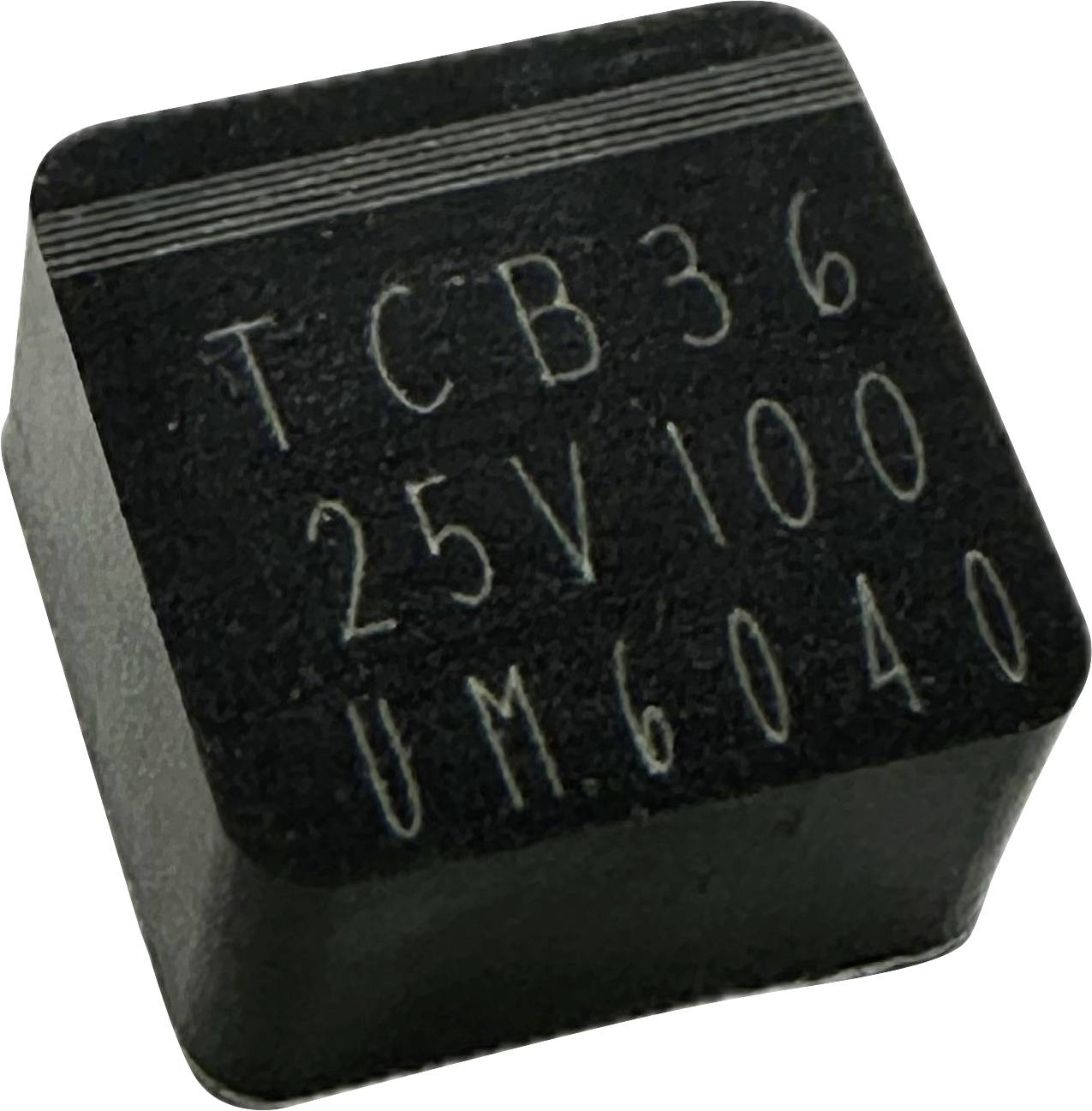 Un circuit intégré électronique noir, carré, portant l'inscription « TCB36 25V100 UM6040 » sur sa face supérieure.