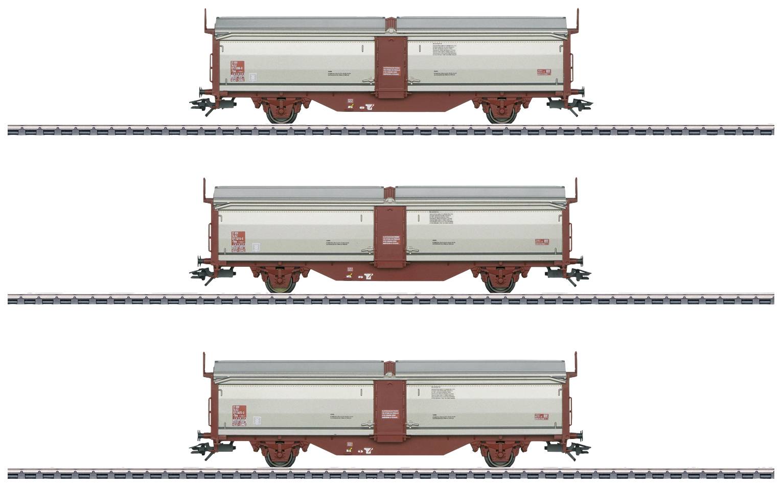 Trois wagons de marchandises ouverts sur des rails, alignés. Chaque wagon a des côtés gris et un châssis rouge.