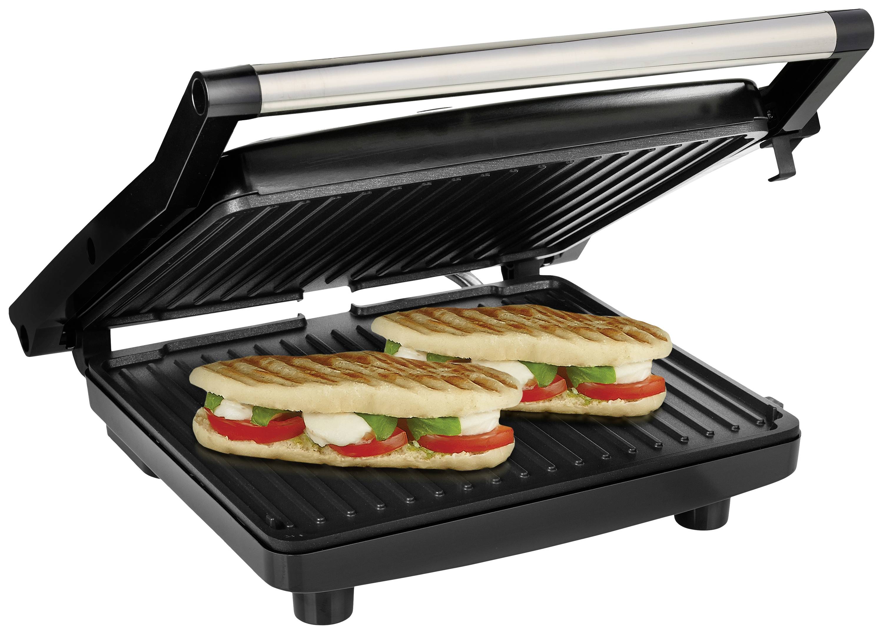 Un grill à panini ouvert avec deux sandwichs panini grillés, garnis de tomates, de basilic et de mozzarella.