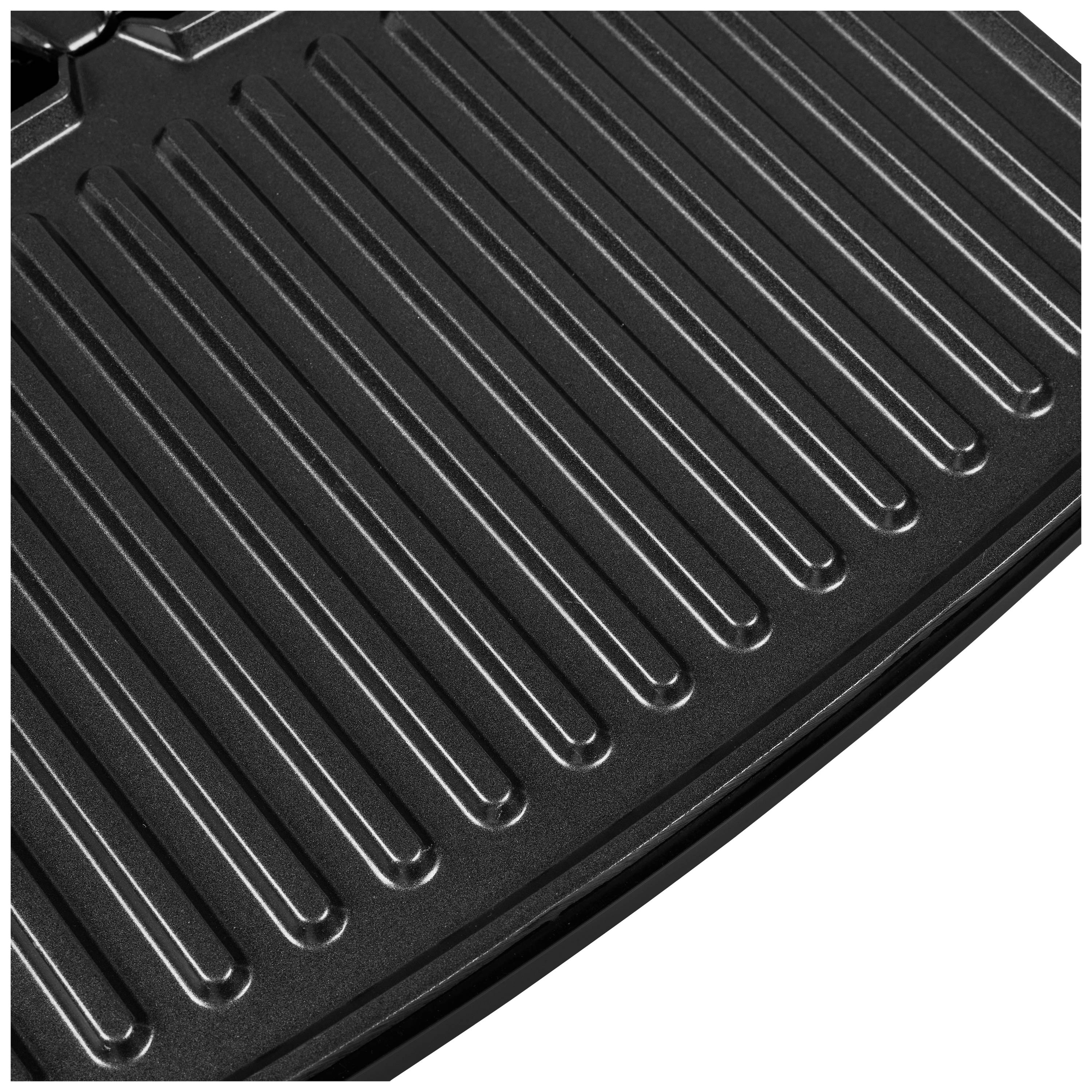Gros plan d'une grille de barbecue en métal noir brillant, montrant des rainures parallèles conçues pour griller et laisser s'écouler la graisse.