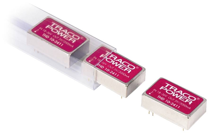 Trois modules d'alimentation TRACO dans un boîtier rouge, numéro de modèle THD 10-2411, disposés côte à côte avec un récipient en plastique vide.
