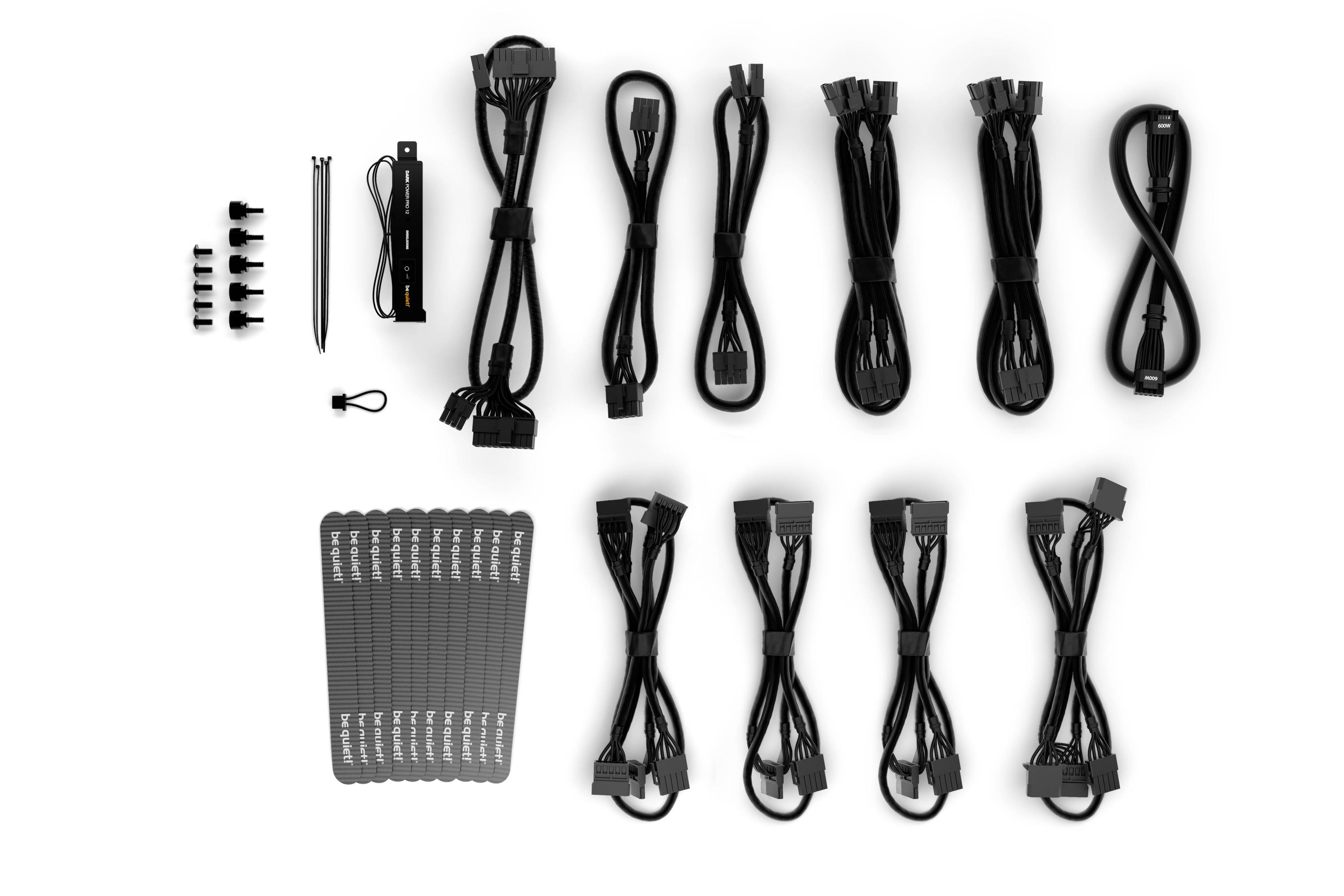 Un ensemble de différents câbles d'ordinateur noirs et d'accessoires, organisés en rangées sur un fond blanc, y compris des attache-câbles.
