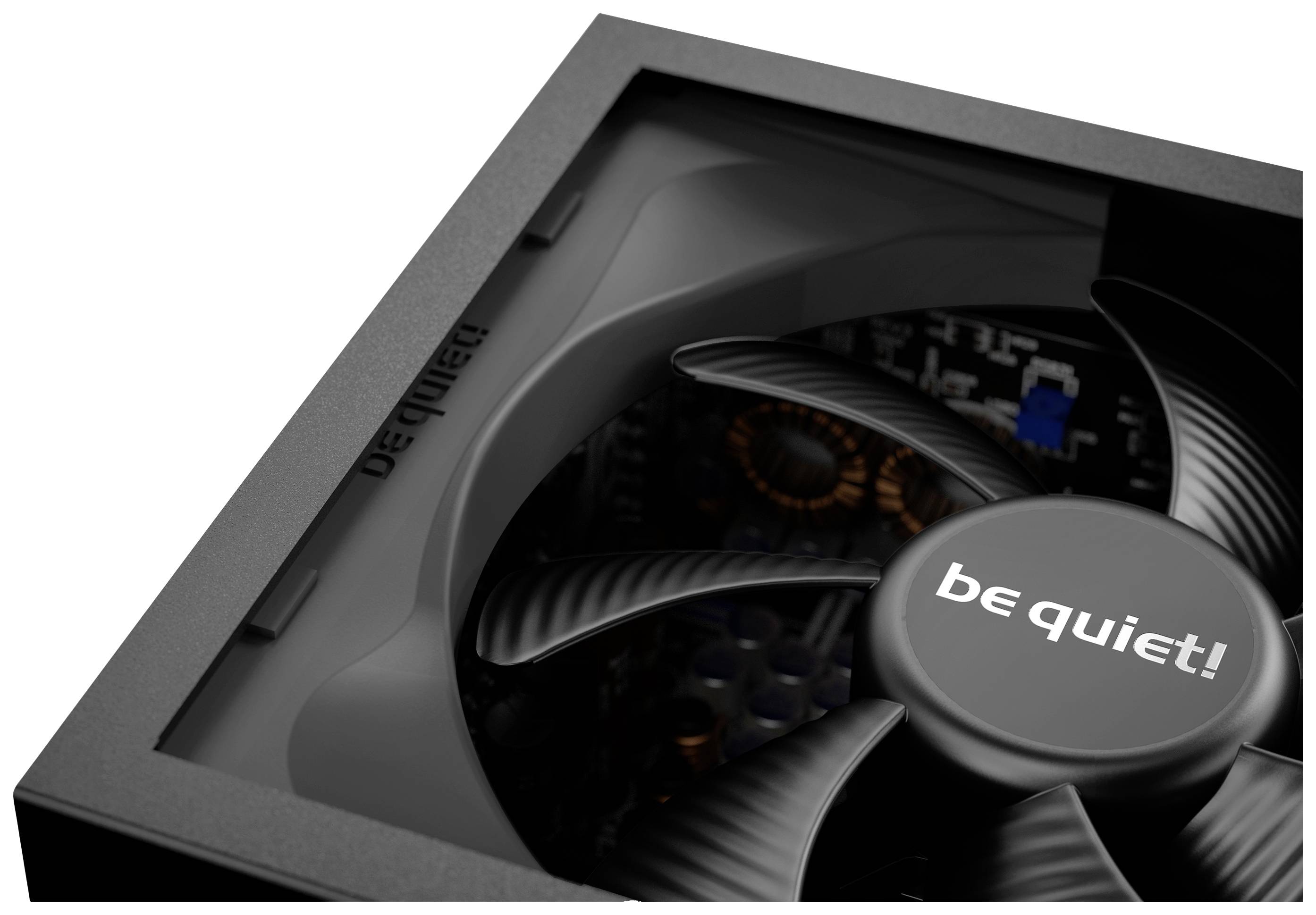 Gros plan d'une alimentation PC avec un ventilateur noir portant le logo 'be quiet!'. Éclairage tamisé révélant les composants techniques internes.