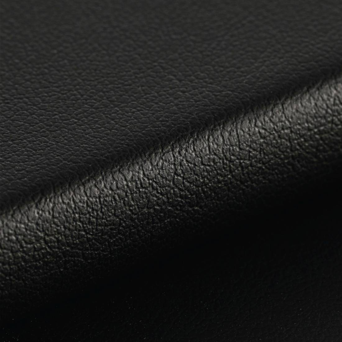 Gros plan sur du cuir noir avec une texture grenue fine et visible.
