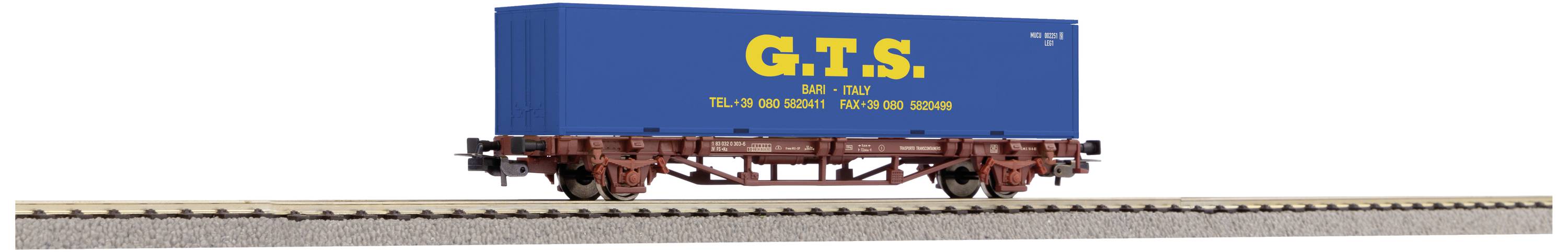 Un wagon de marchandises sur une voie ferrée, chargé d'un conteneur bleu portant l'inscription jaune 'G.T.S.'.