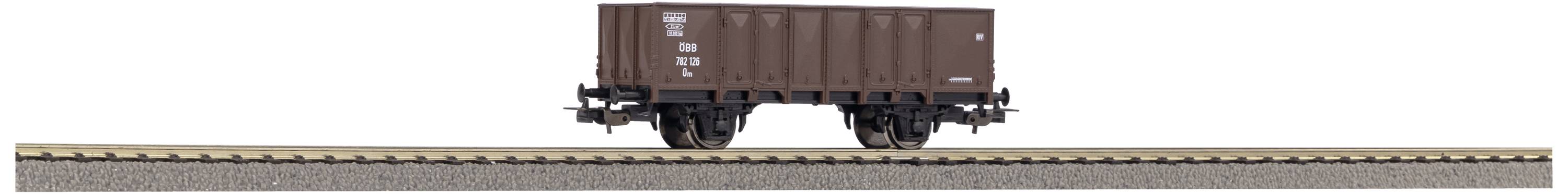 Un wagon de marchandises marron est stationné sur une voie ferrée.