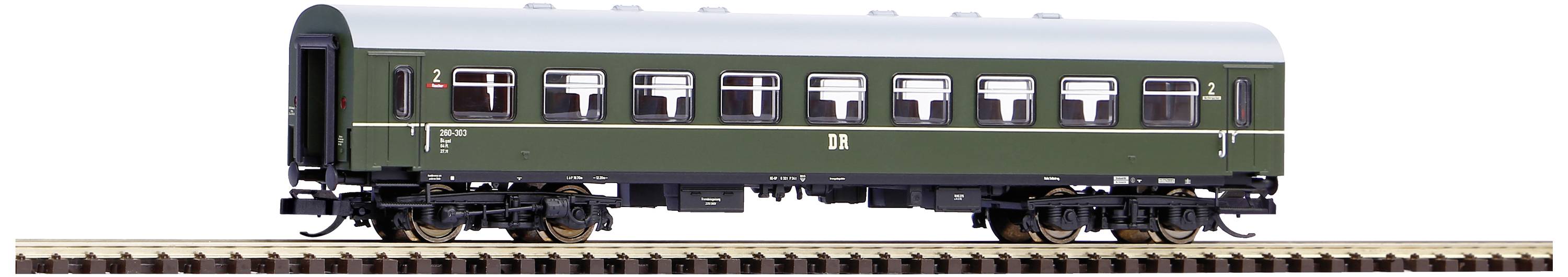 Wagon de chemin de fer vert sur des rails, peint en vert foncé avec des fenêtres blanches, aucune personne visible, vue de côté.