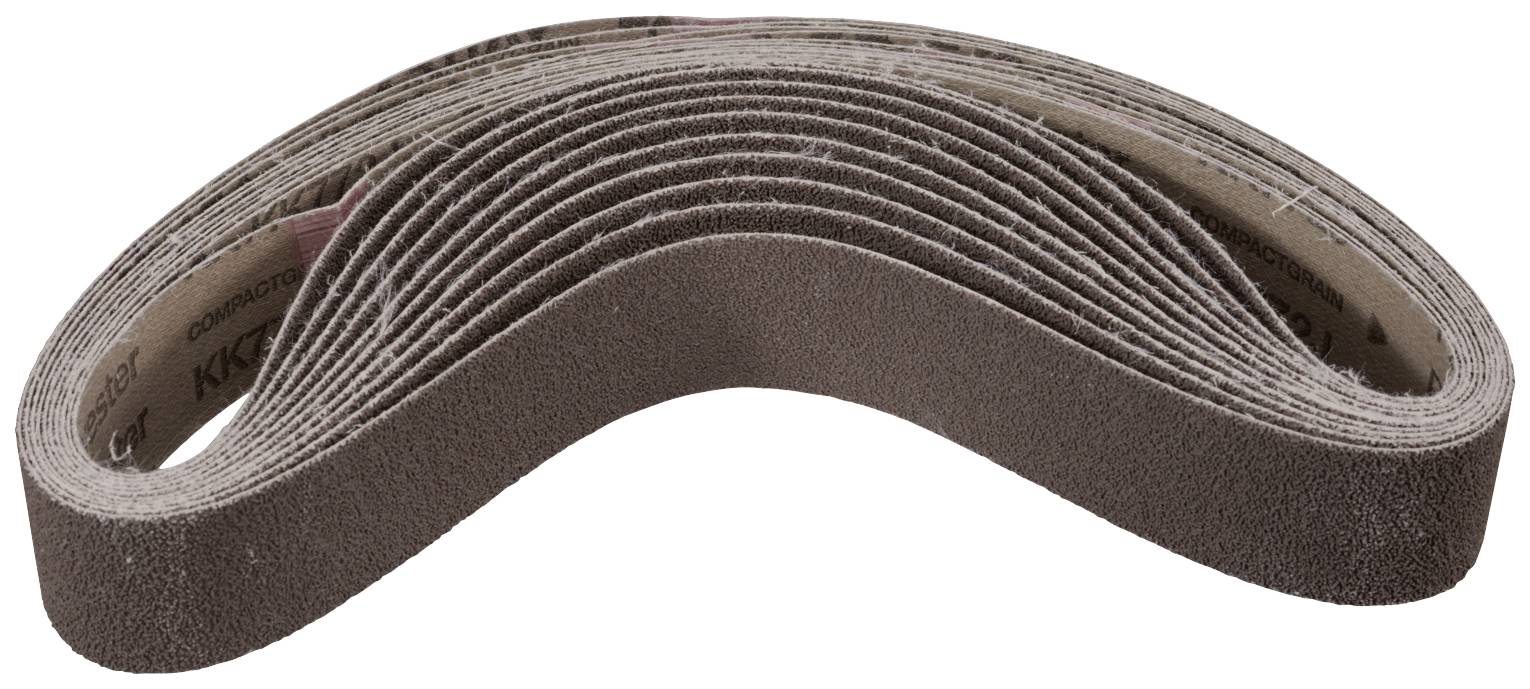 Une pile de bandes abrasives sous une forme incurvée, utilisées pour poncer des surfaces, dans un environnement d'atelier.