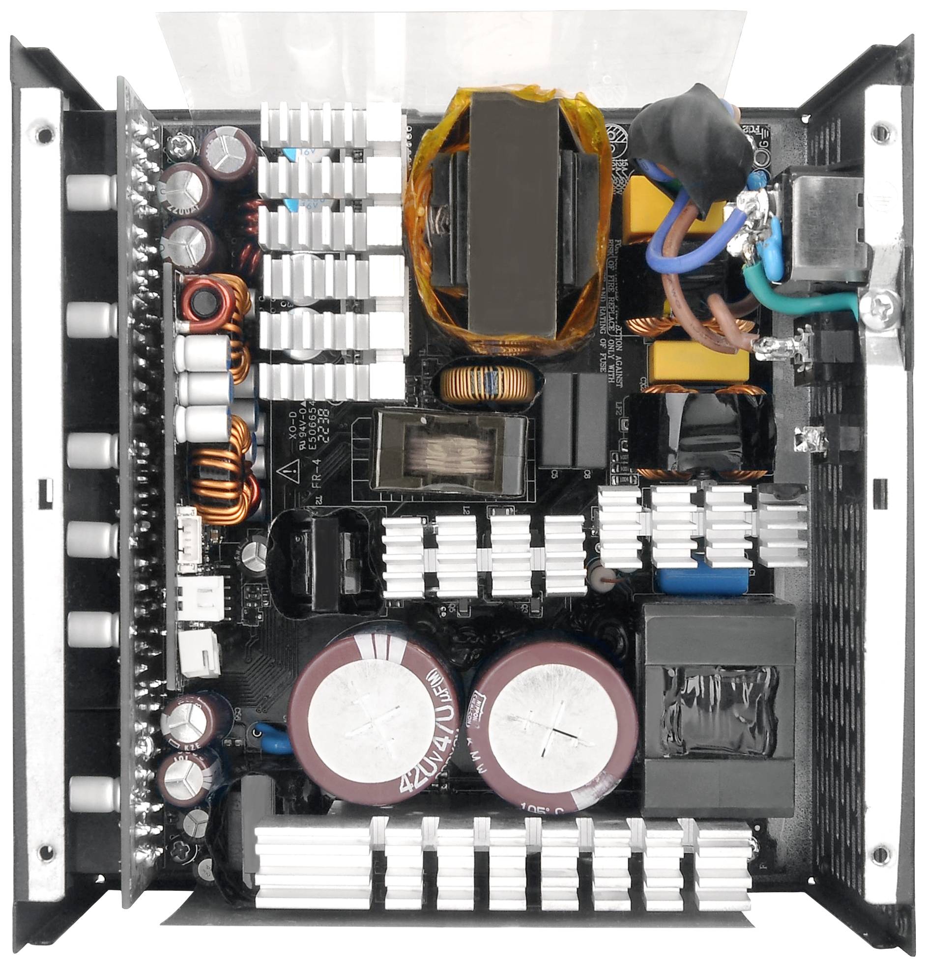 Composant électronique avec plusieurs composants et ailettes de refroidissement. Vue de dessus montrant des condensateurs et des connexions de câbles dans un bloc d'alimentation.