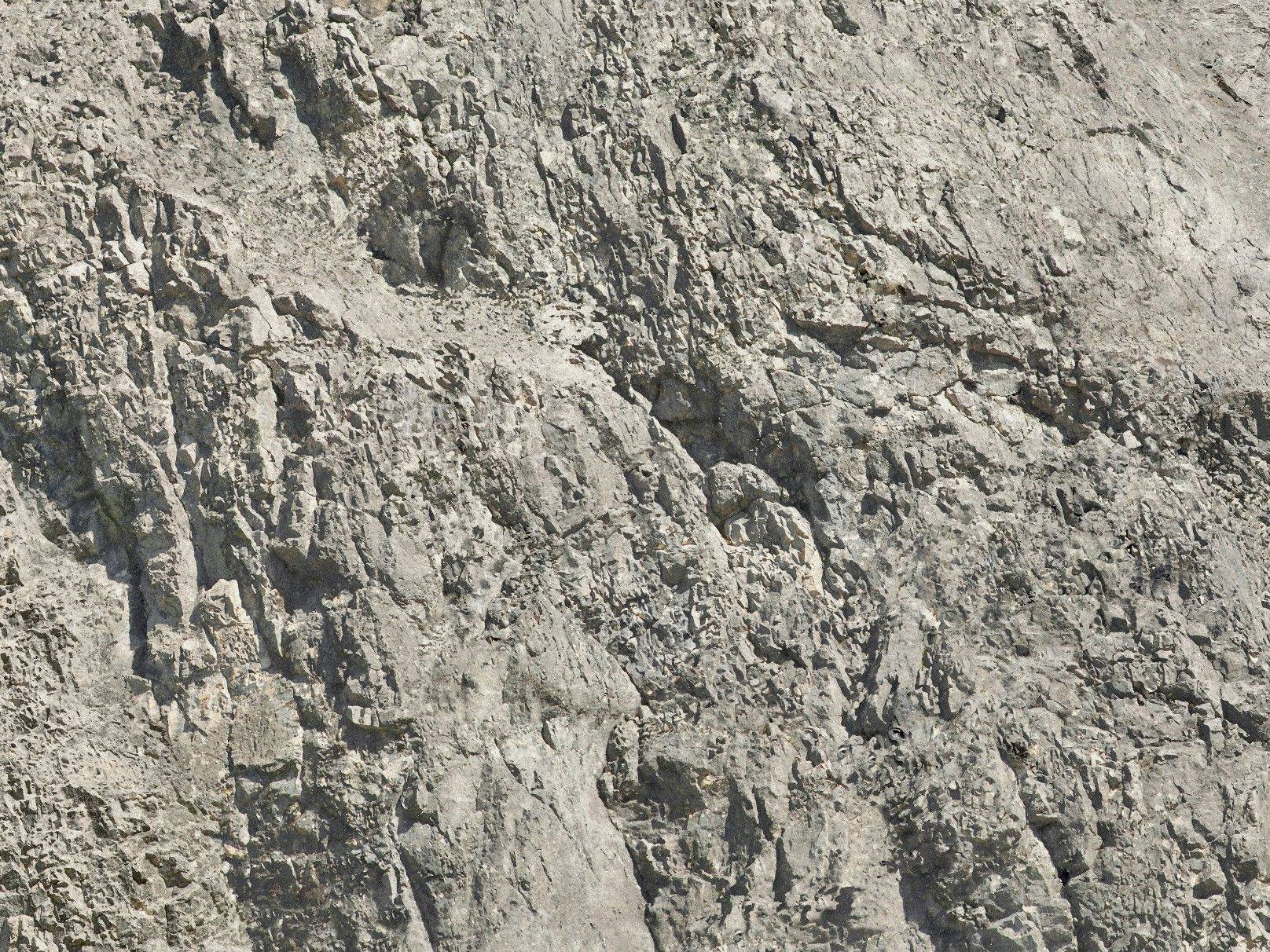Une surface rocheuse à la structure irrégulière et aux différentes nuances de gris.