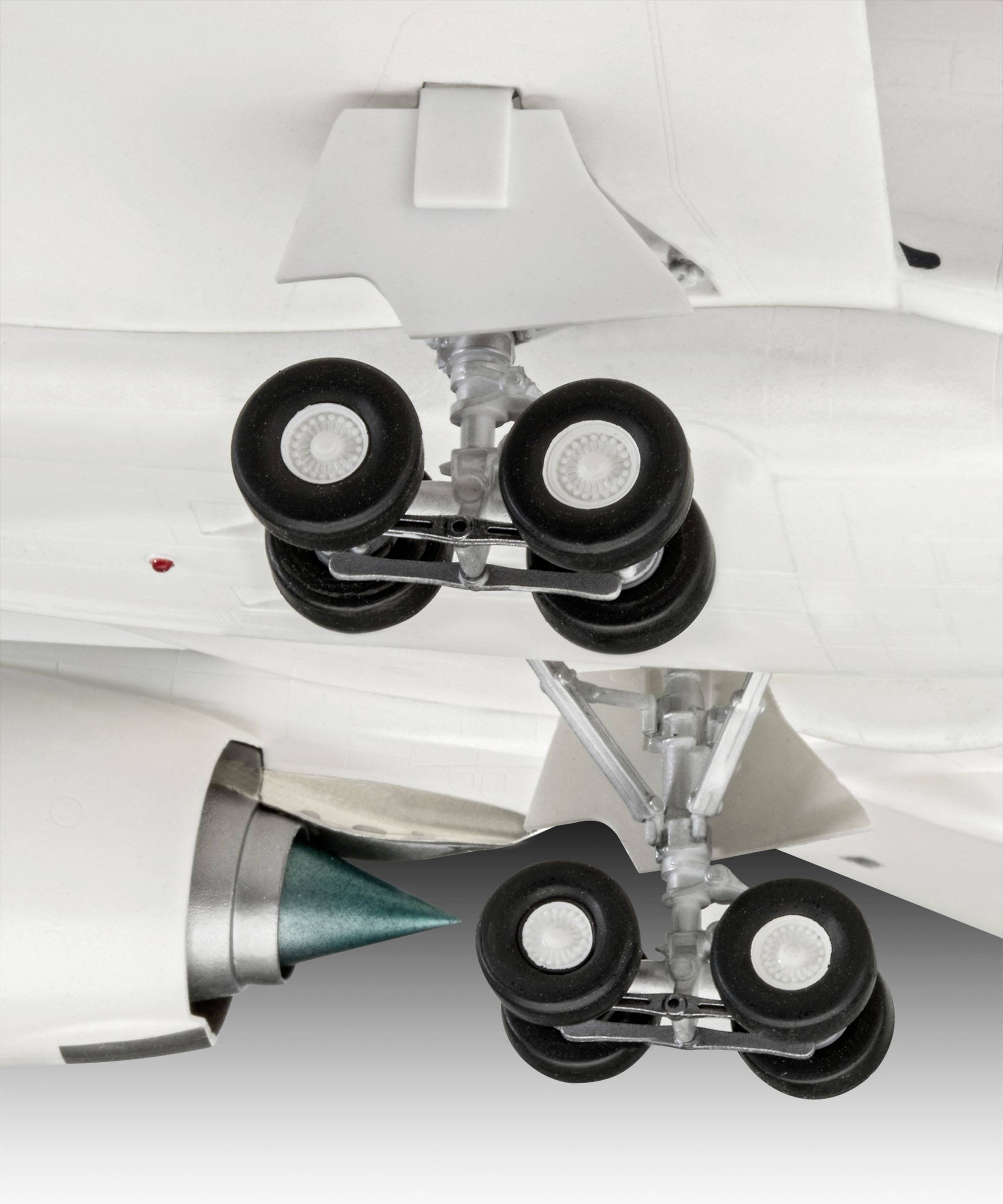 Gros plan sur le train d'atterrissage et le moteur sous une aile d'avion, révélant des détails techniques des pneus et de la structure du train.