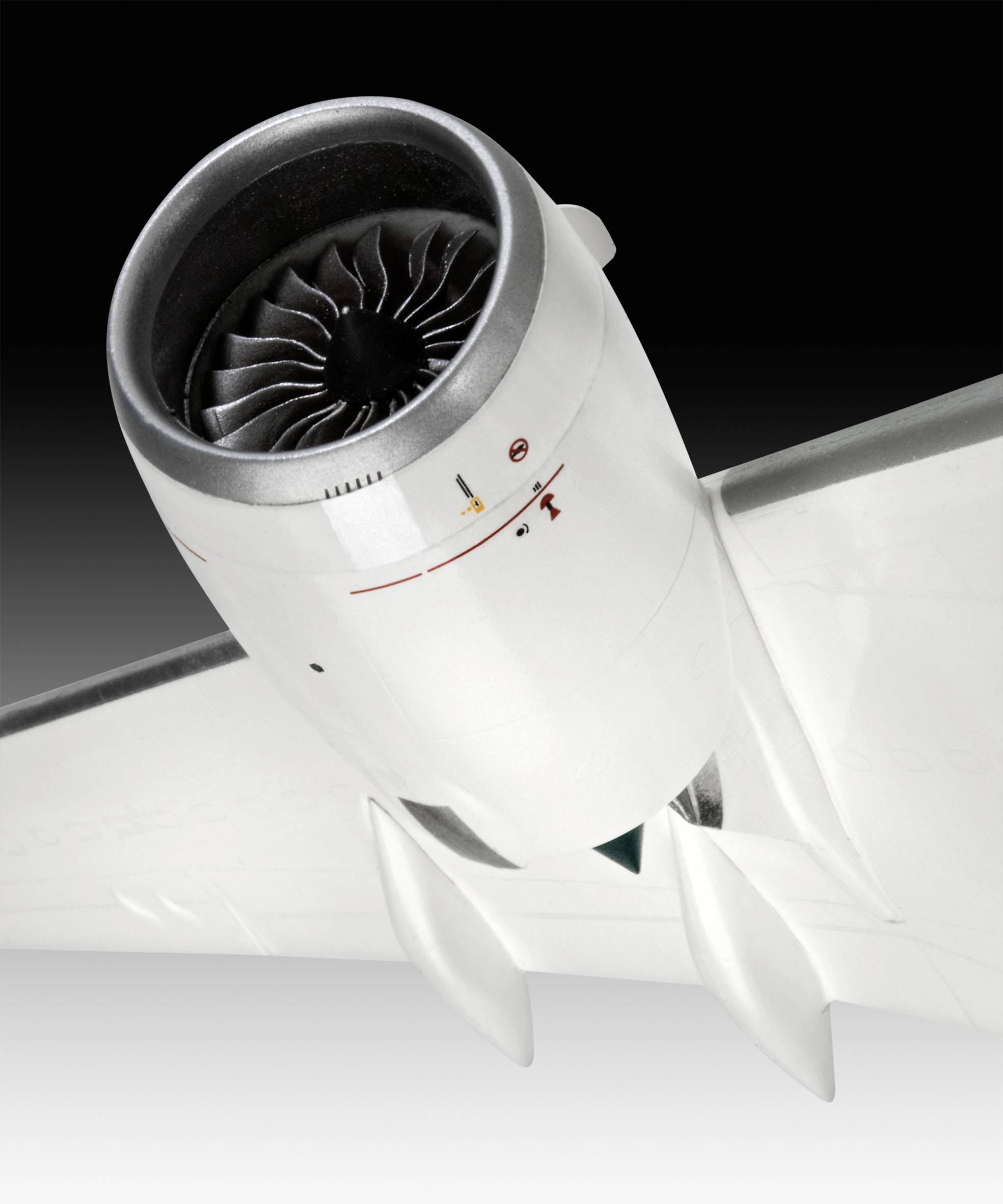 Un gros plan d'un moteur d'avion sous l'aile d'un avion, mis en valeur sur un fond noir.