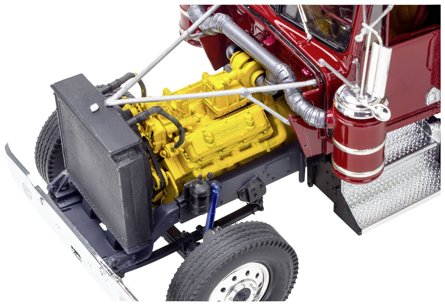 Un modèle de camion avec un capot ouvert révèle un moteur jaune détaillé ainsi que des éléments chromés et des roues.