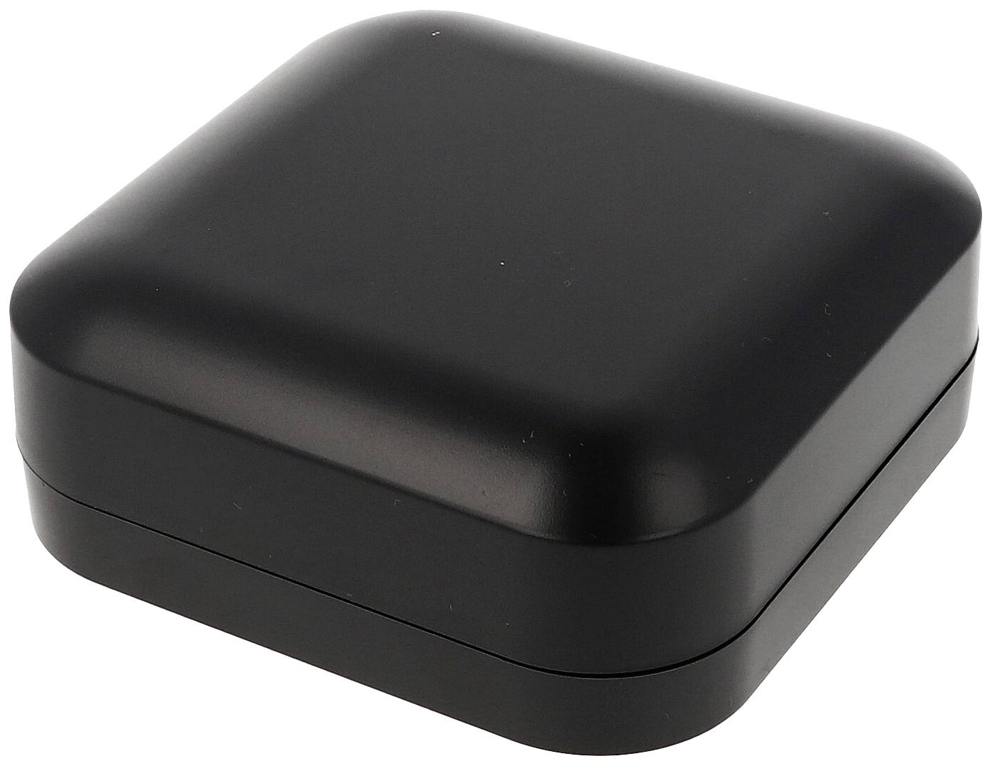 Une petite boîte noire carrée aux coins arrondis, possiblement un étui ou un coffret à bijoux.