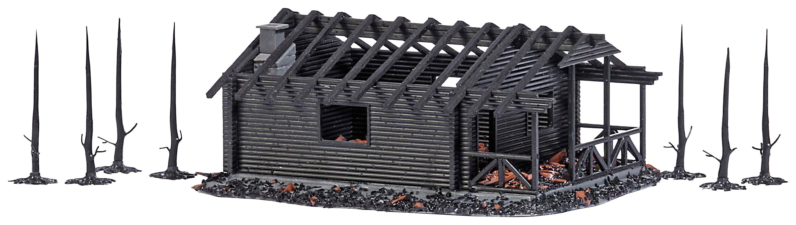 Une maison en bois abandonnée et à moitié délabrée, sans toit, entourée d'arbres nus et noircis. Des cendres et des décombres sont dispersés tout autour.