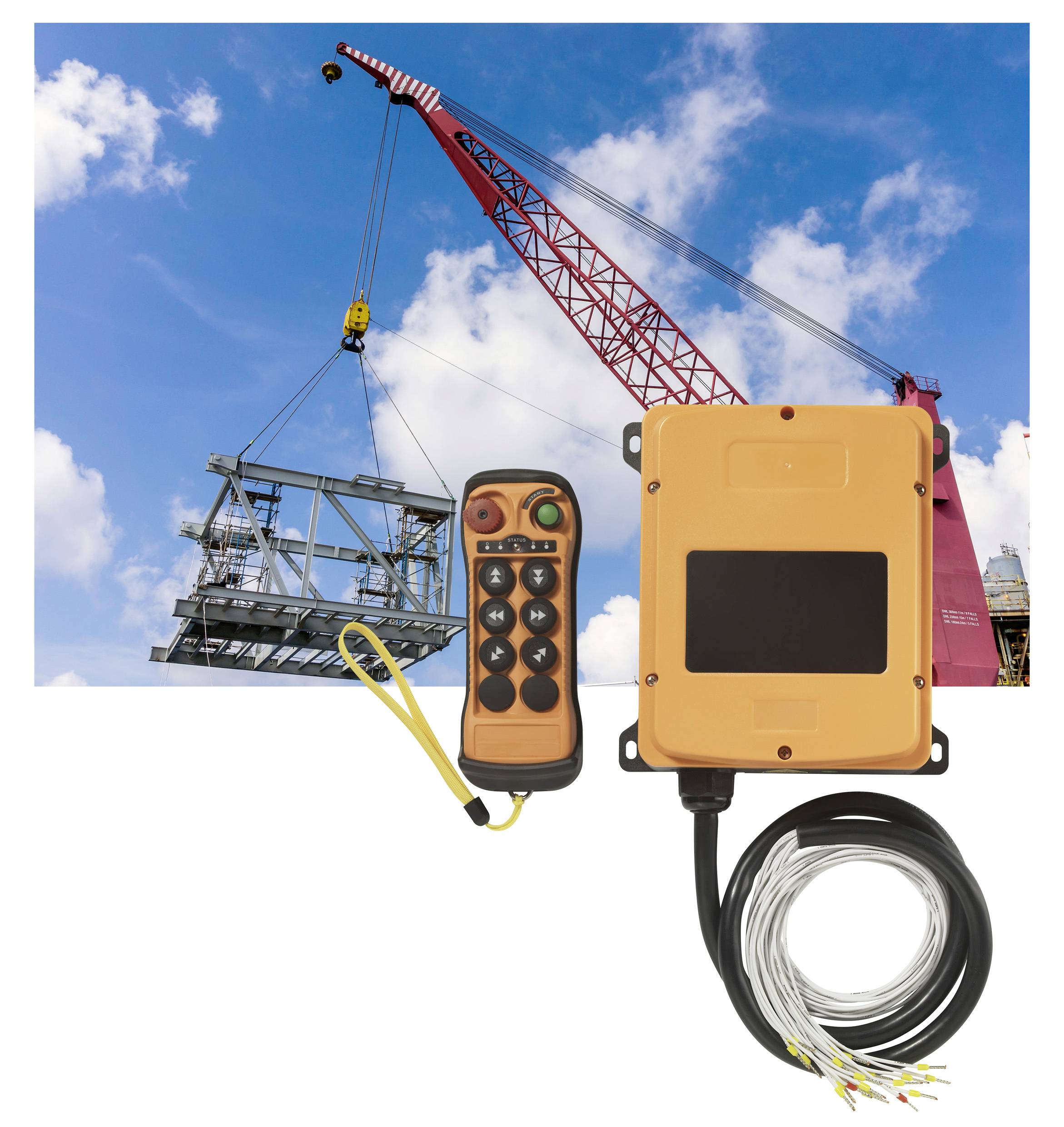 Une grue rouge soulève une structure métallique vers le ciel. À côté se trouvent une télécommande orange et un dispositif de commande électrique.