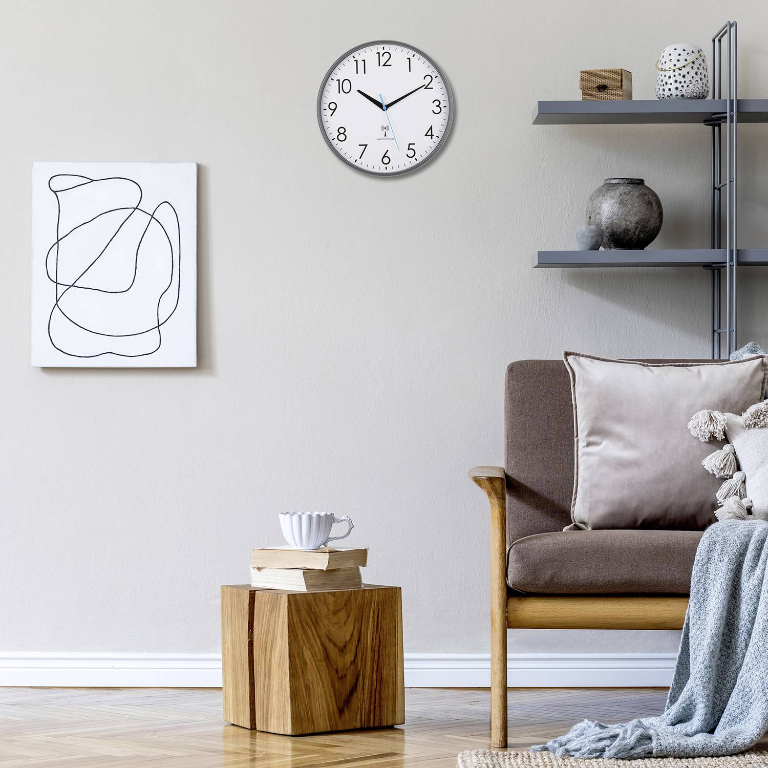 Un salon élégamment aménagé avec un fauteuil marron, une table en bois, une œuvre d'art moderne accrochée au mur et une horloge murale.