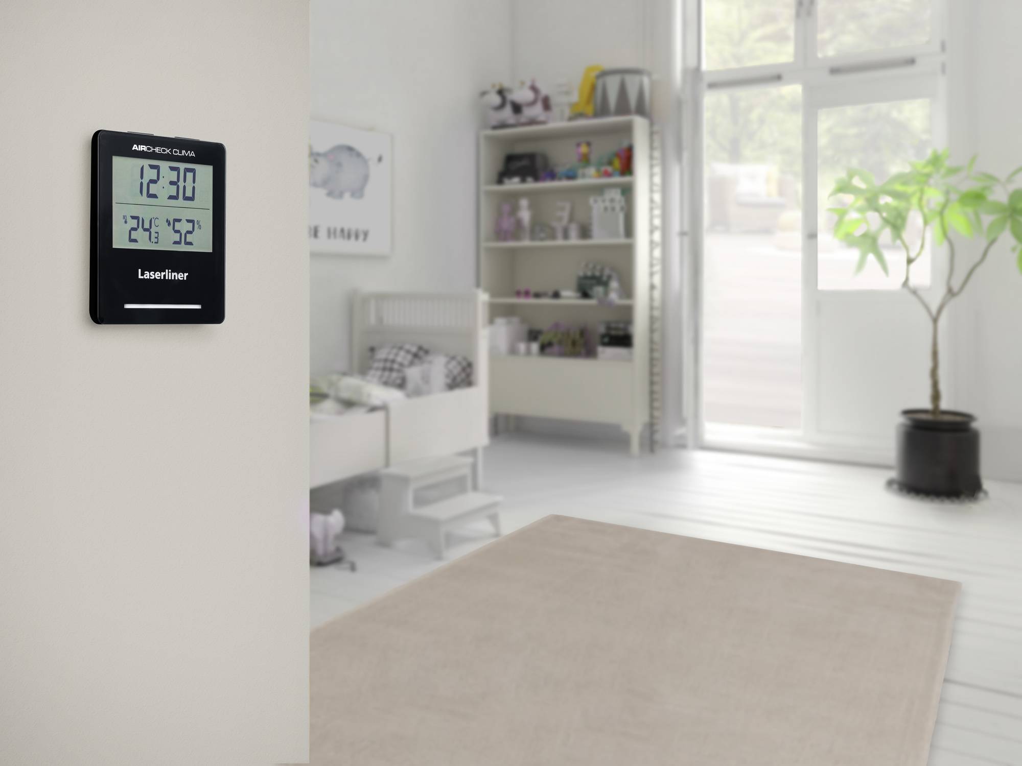 Une chambre d'enfant avec un sol moquetté, un lit et une étagère remplie de jouets. Un thermomètre numérique est accroché au mur à gauche.